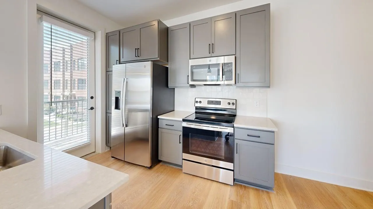 Modern kitchen with sleek stainless steel appliances, elegant gray cabinetry, and a bright, airy atmosphere.