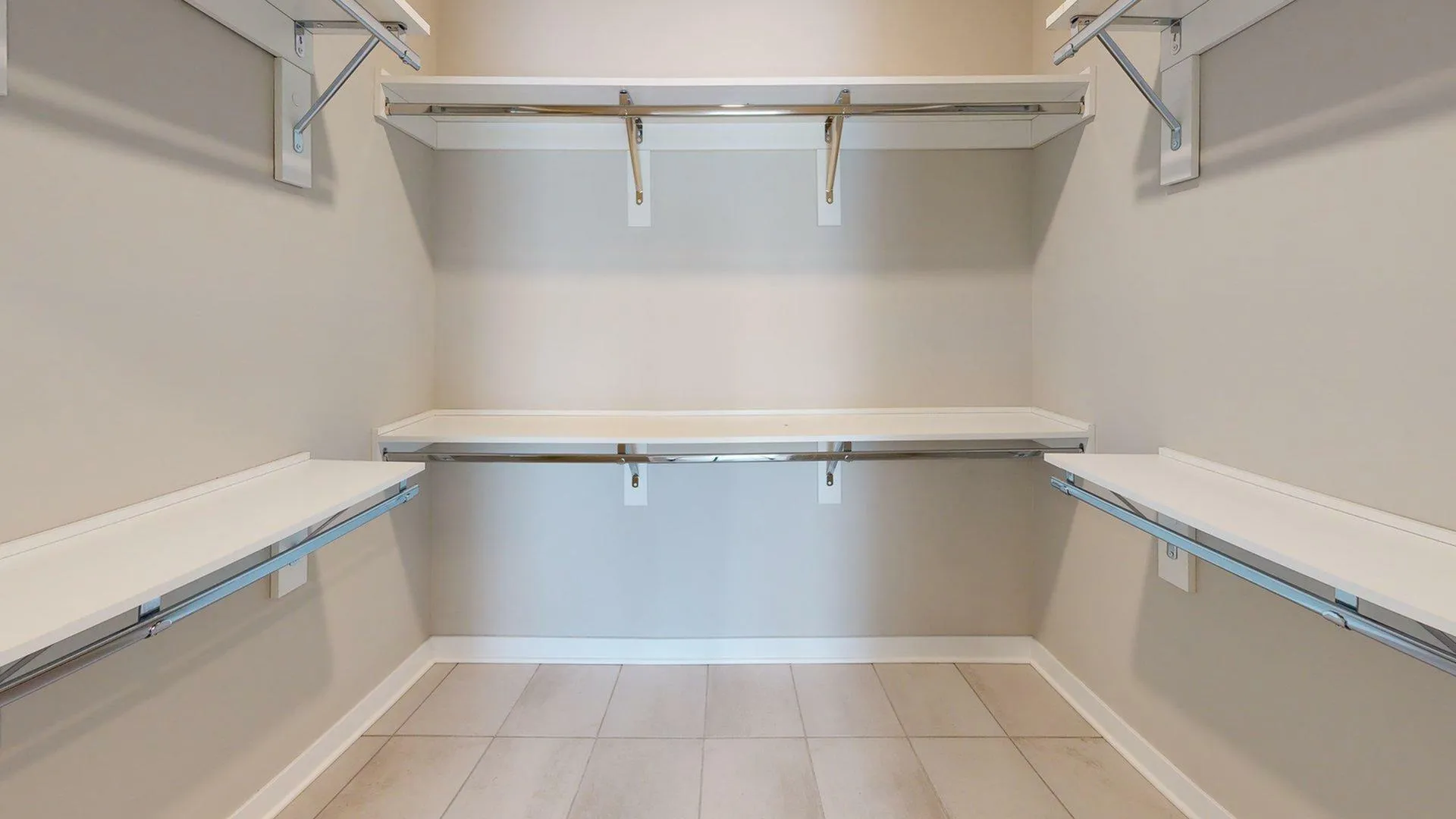 Spacious walk-in closet with sleek white shelving and ample storage space.