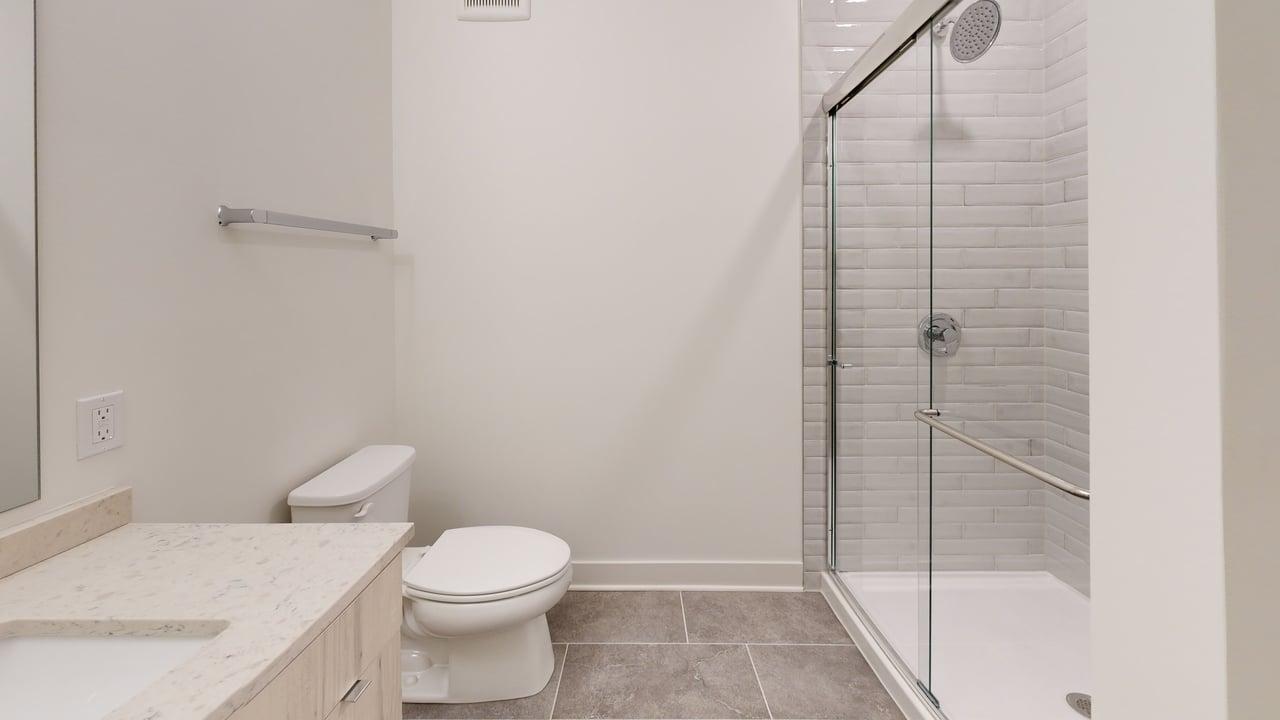 Modern bathroom with sleek shower, elegant vanity, and stylish tile flooring.
