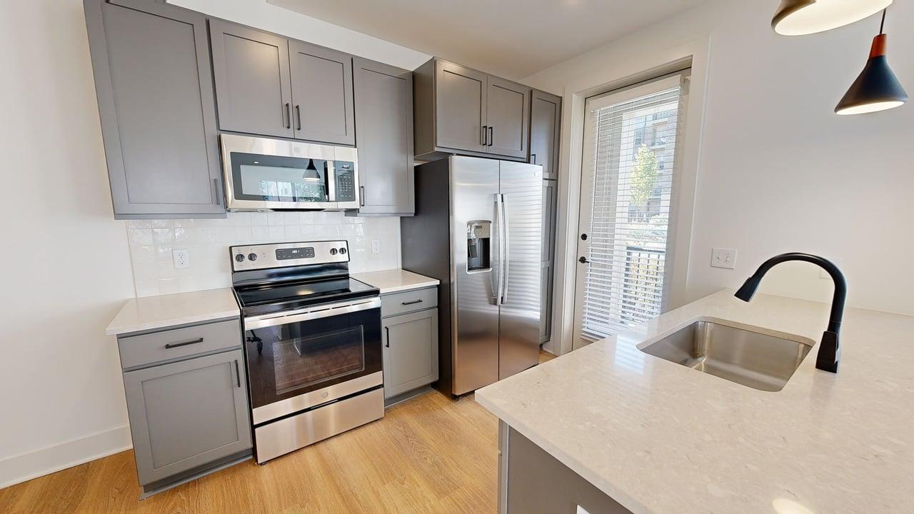 Modern kitchen with sleek stainless steel appliances, elegant gray cabinetry, and a bright, airy atmosphere.