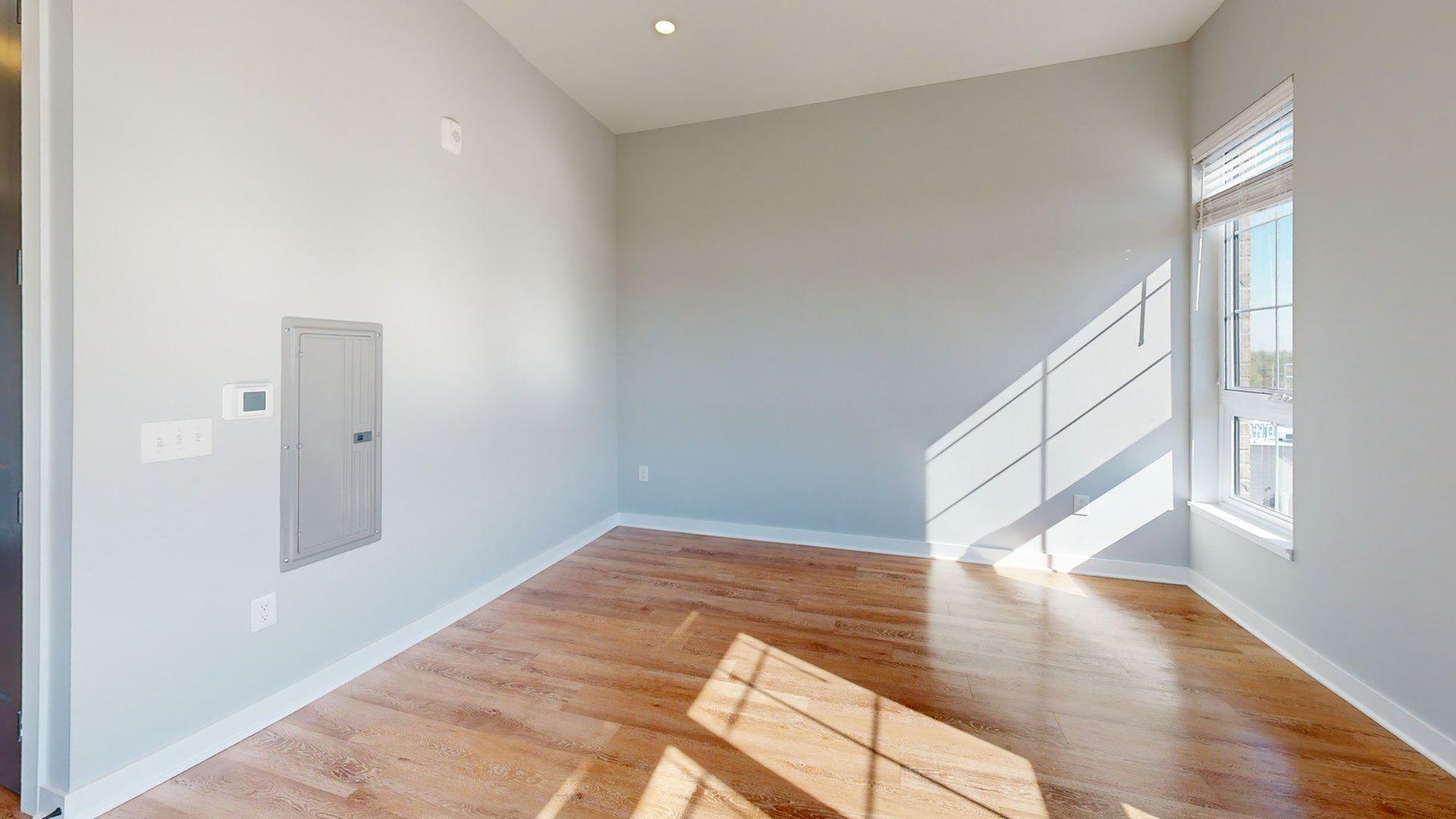 Bright, spacious room with natural light flooding through large windows, creating a warm and inviting atmosphere.