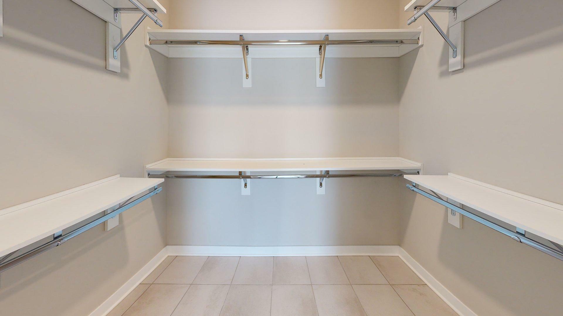 Spacious walk-in closet with sleek shelving and ample hanging space, perfect for organizing your wardrobe.