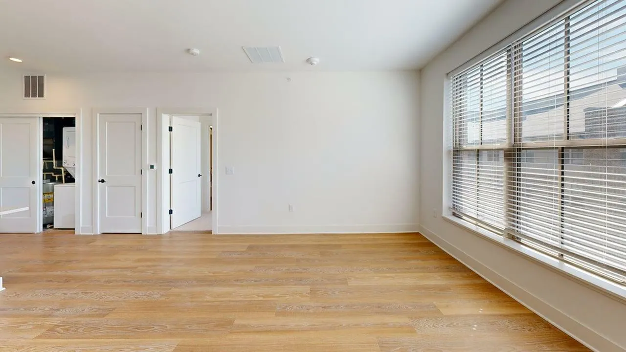 Bright and spacious open room with hardwood floors and large windows offering ample natural light.