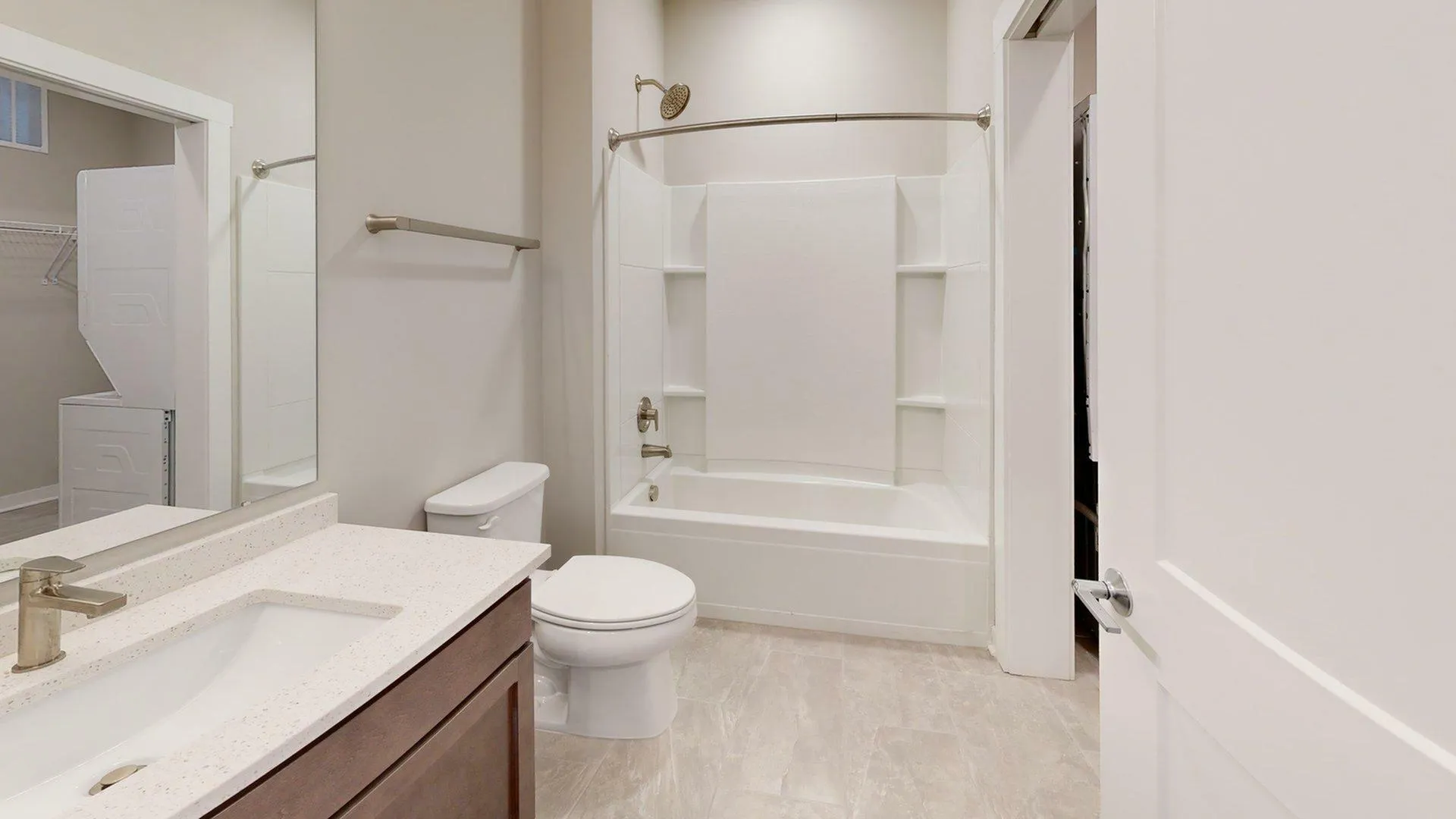 Elegant bathroom with modern fixtures, a sleek vanity, and a convenient in-unit laundry area.