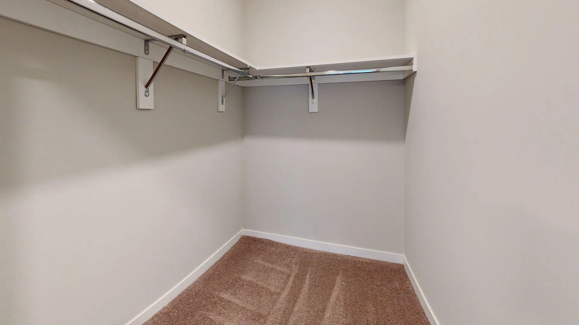 Spacious walk-in closet with ample shelving and hanging space, perfect for organization.