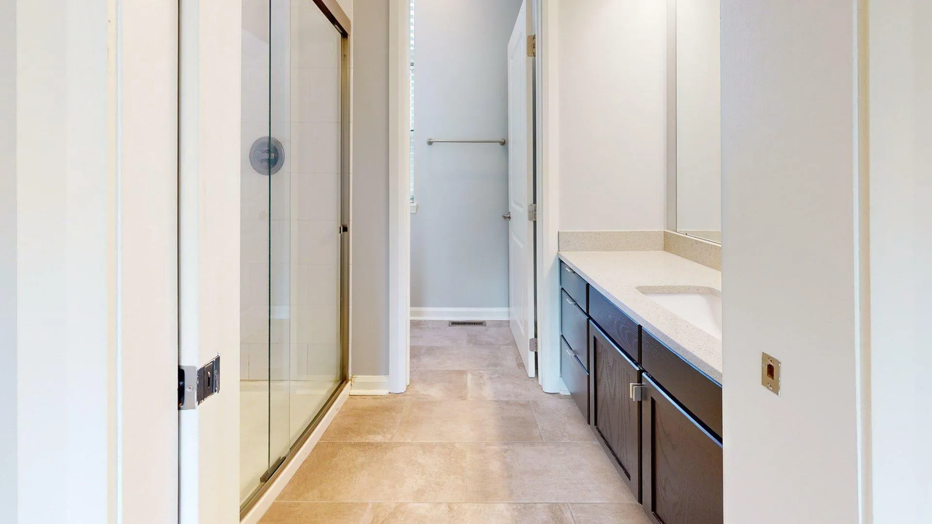 Bright modern bathroom with sleek glass shower enclosure and elegant vanity with ample storage.