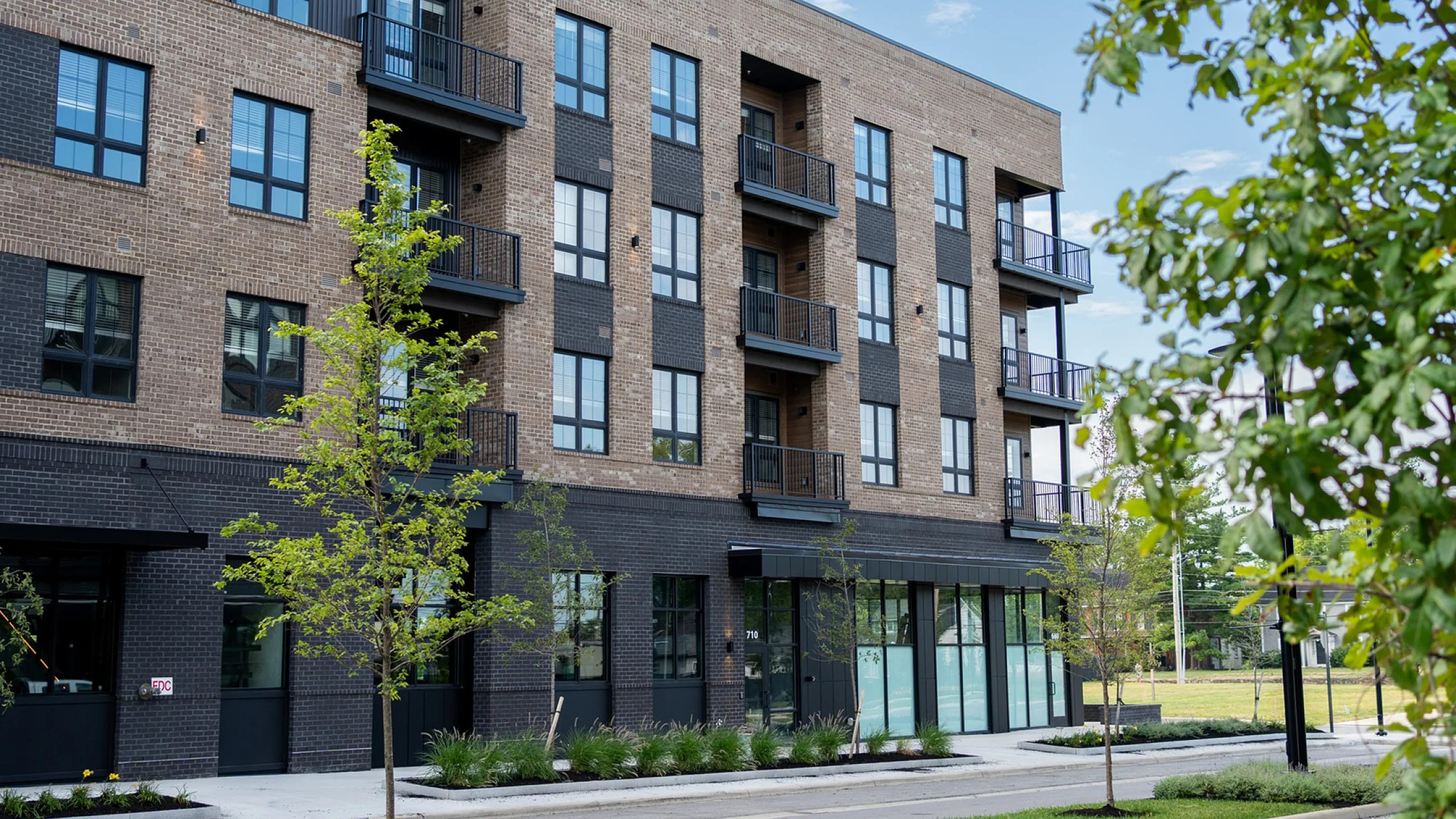 Contemporary multistory apartment building with brick facade and modern balconies.