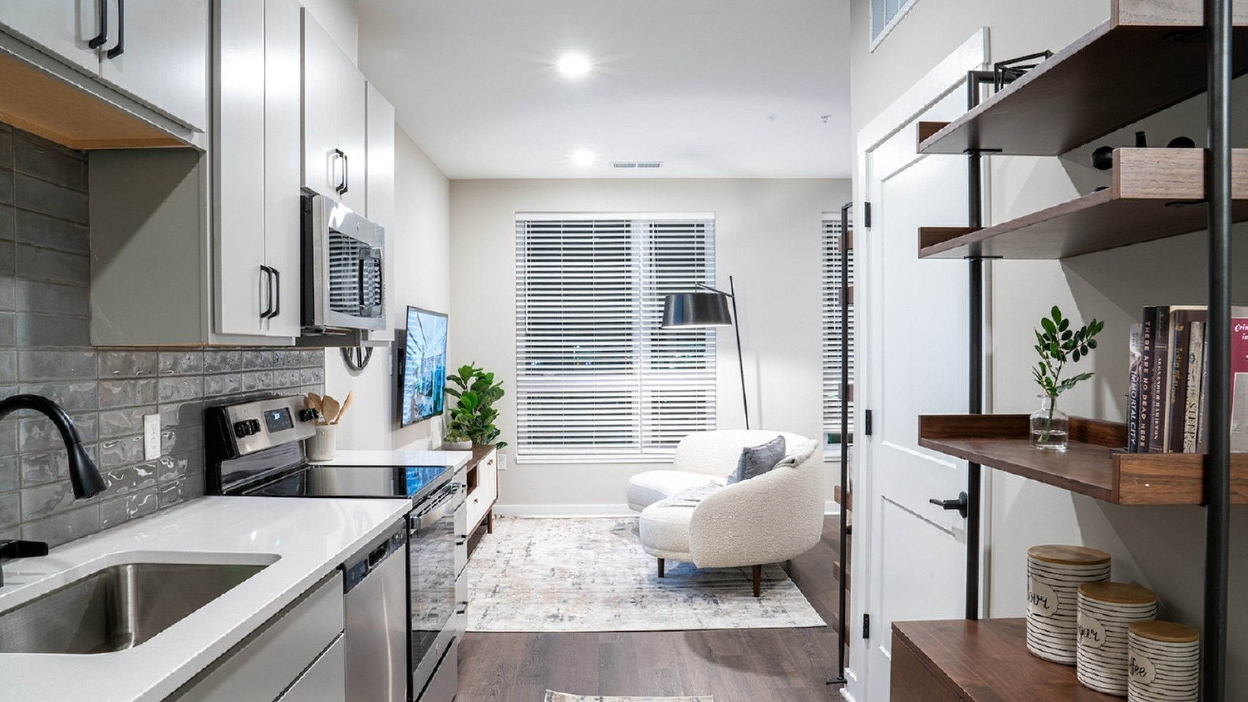 Modern kitchen with sleek cabinetry and cozy living room featuring elegant furnishings and natural light.