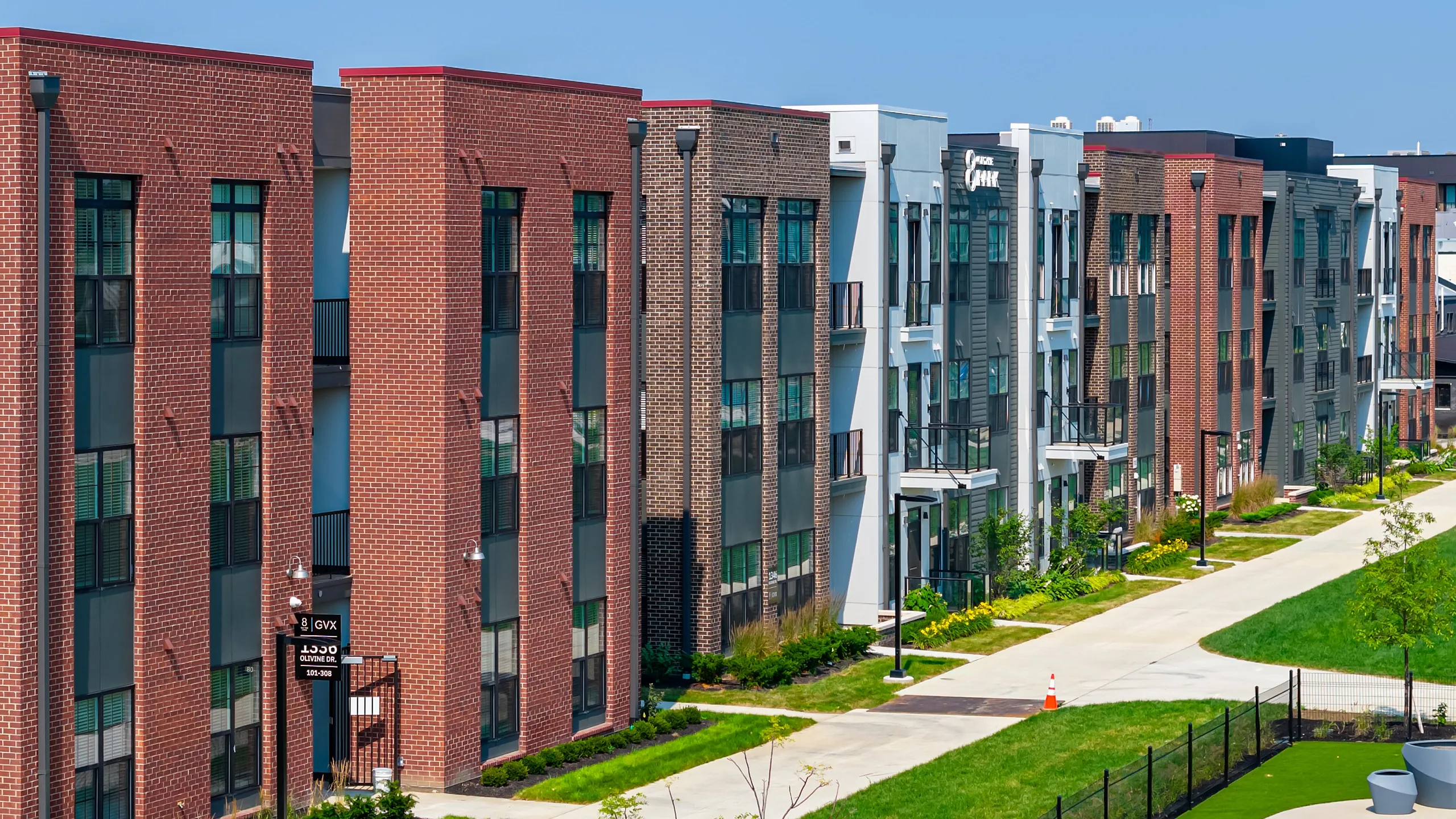 Contemporary apartment complex with modern brick facade and lush green surroundings.