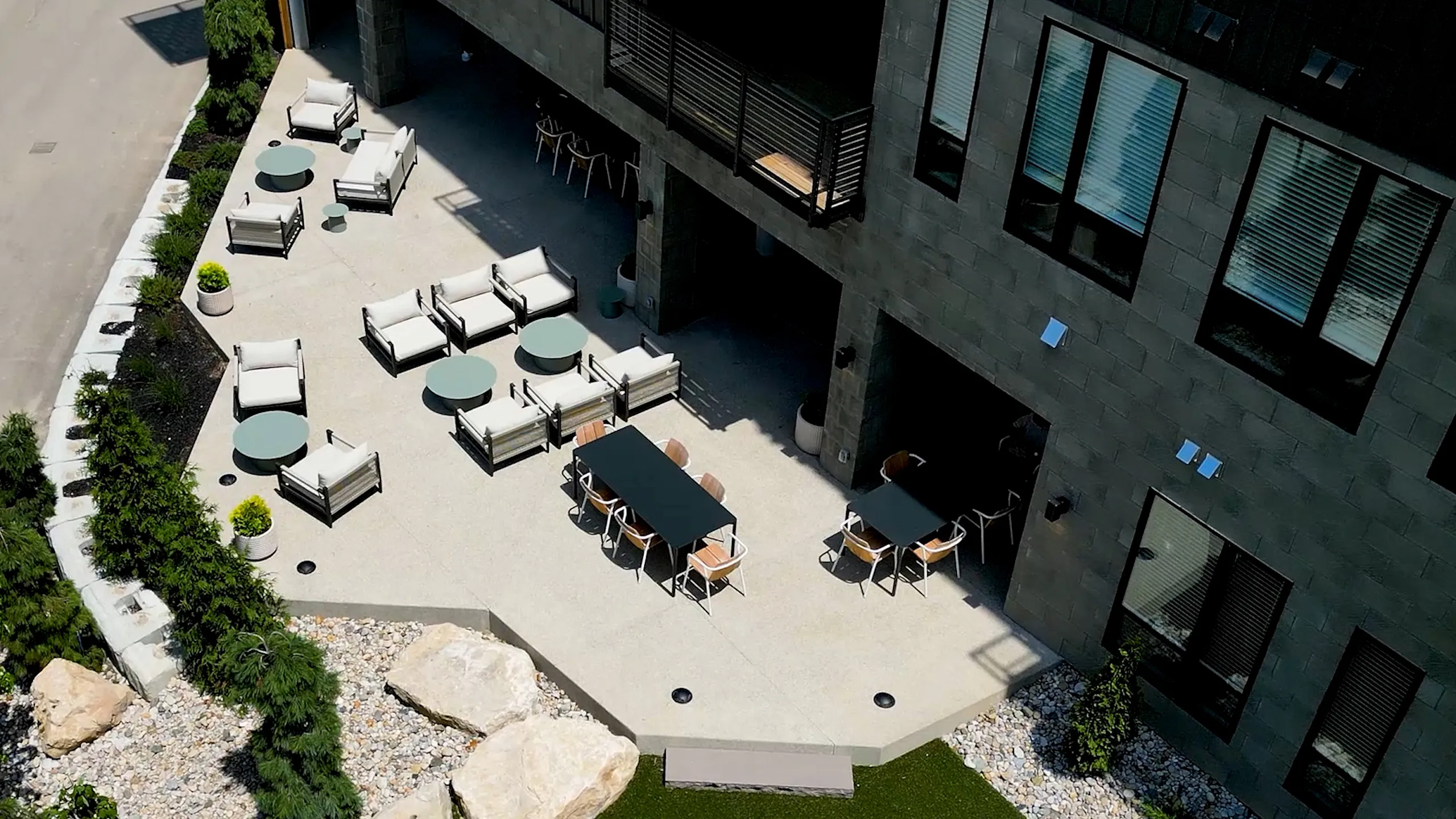 Modern outdoor patio area featuring elegant seating, stylish tables, and lush greenery, perfect for relaxation and social gatherings.