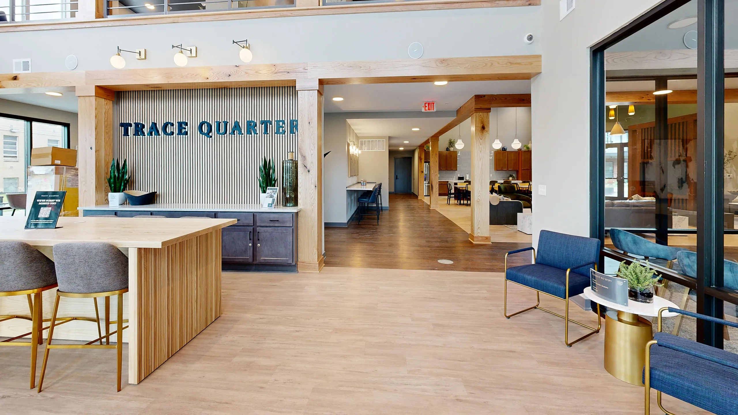 Elegant lobby of Trace Quarter featuring modern seating, stylish wooden accents, and ample natural light.