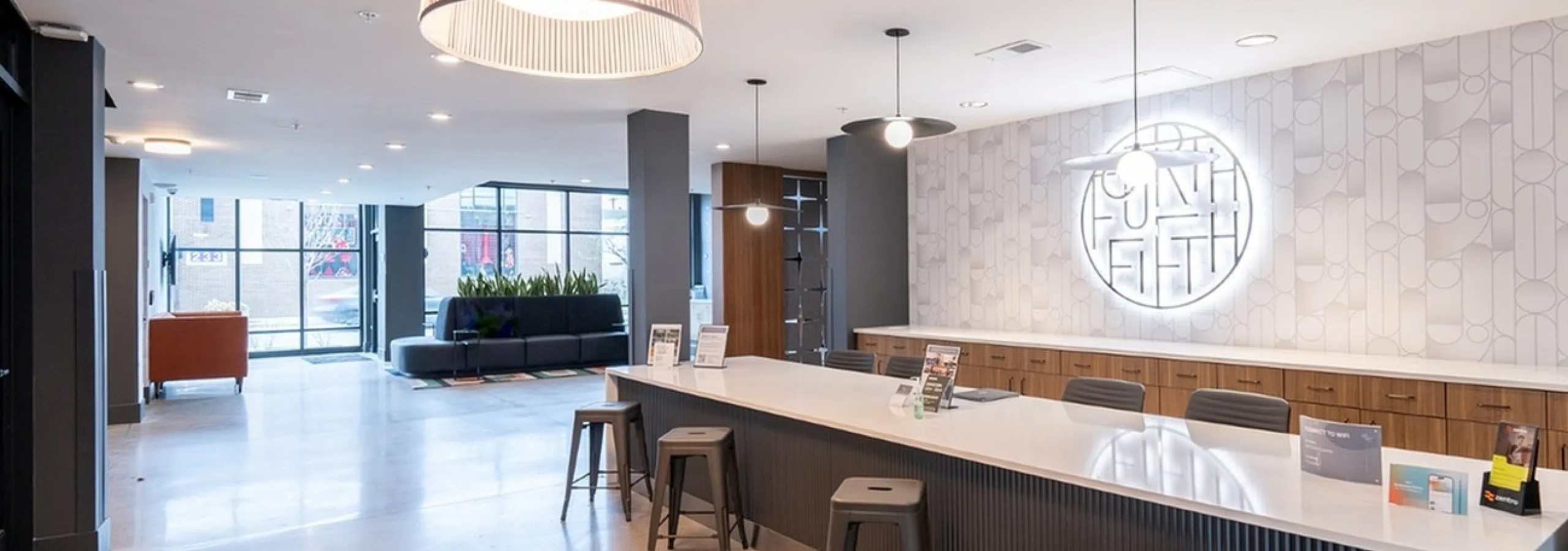 Modern and inviting apartment lobby with sleek design, featuring a welcoming reception area, stylish seating, and ample natural light.