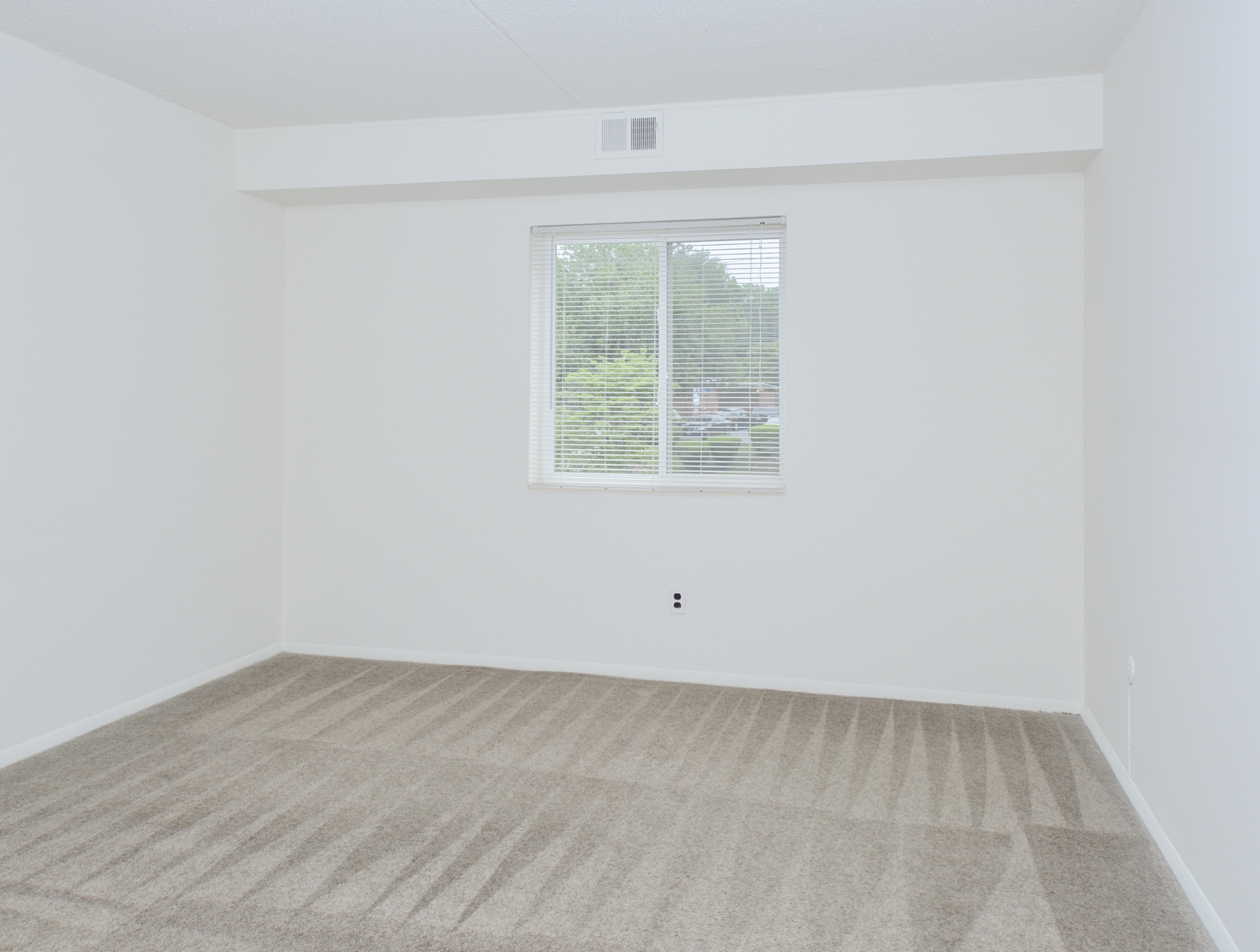 Gladstone Towers Sample Bedroom with Beige Carpet and Window | Apartments in Lansdowne PA