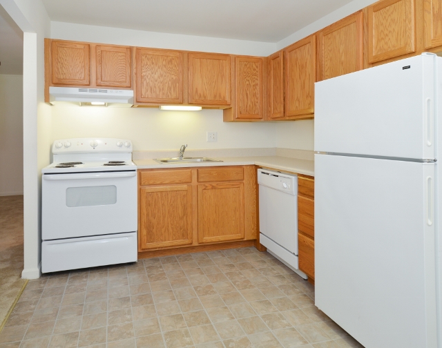 Boothwyn Court Sample Kitchen with Wood Cabinets and White Appliances | Apartments in Garnet Valley, PA