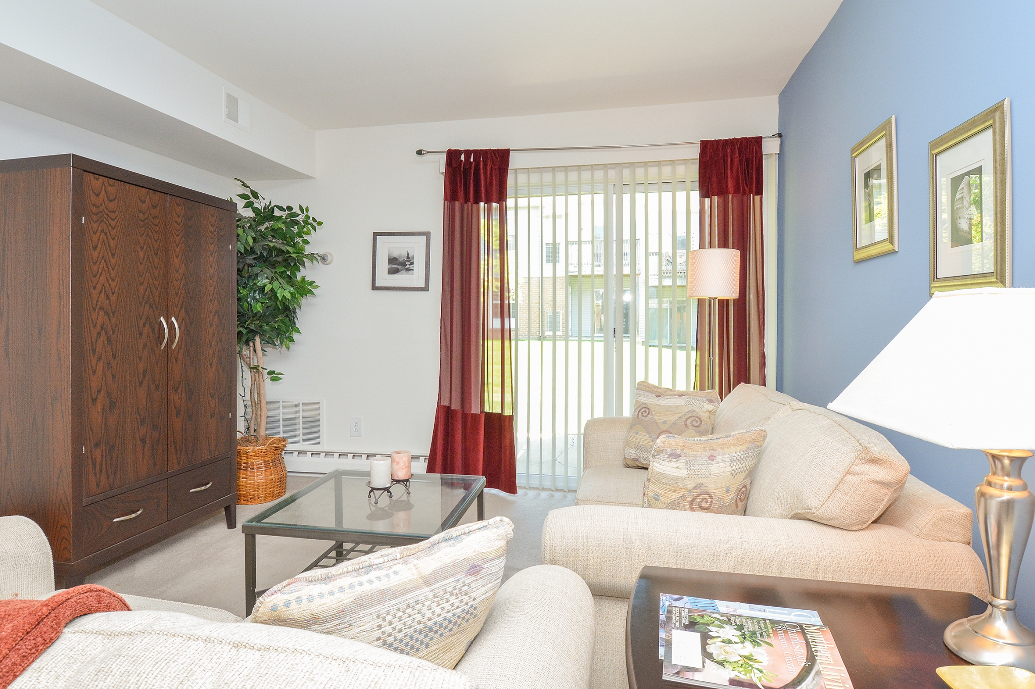 Wyntre Brooke Sample Living Room with Blue Accent Wall and Door to Patio | Apartments Near West Chester