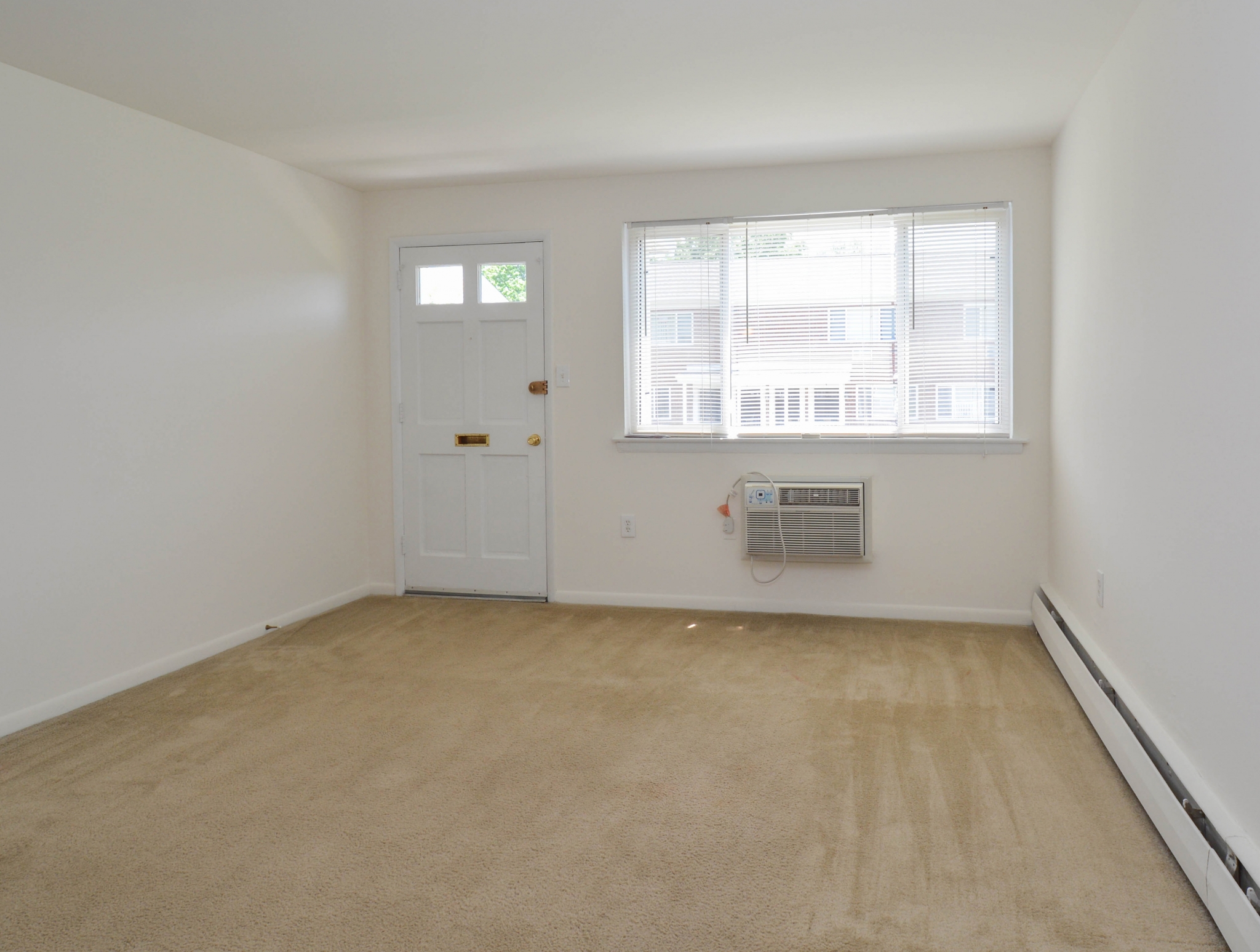 Concord Court Sample Living Room with Front Door and Window | Aston Apartments