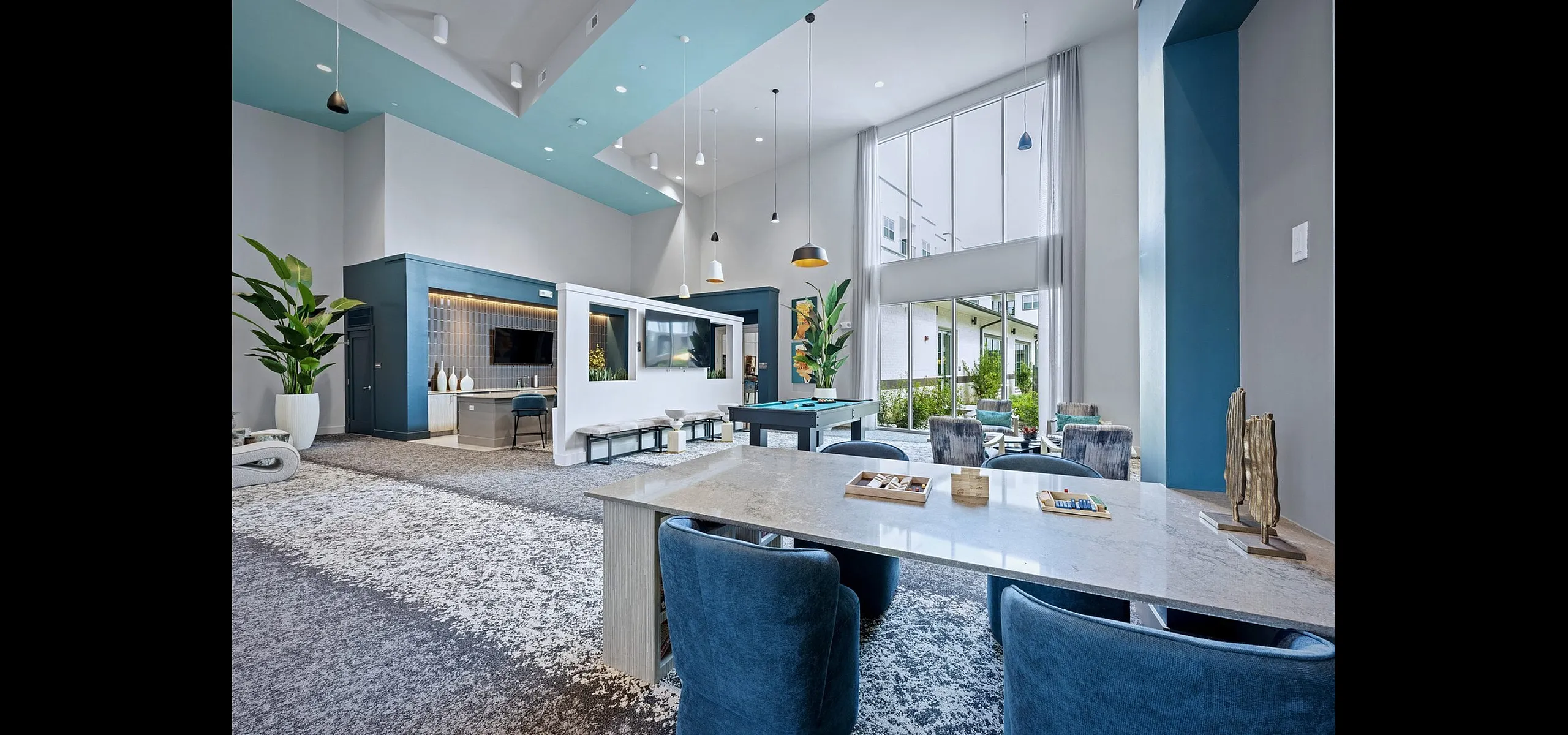 Spacious and modern apartment lounge featuring high ceilings, elegant decor, and a bright, open atmosphere with a pool table.