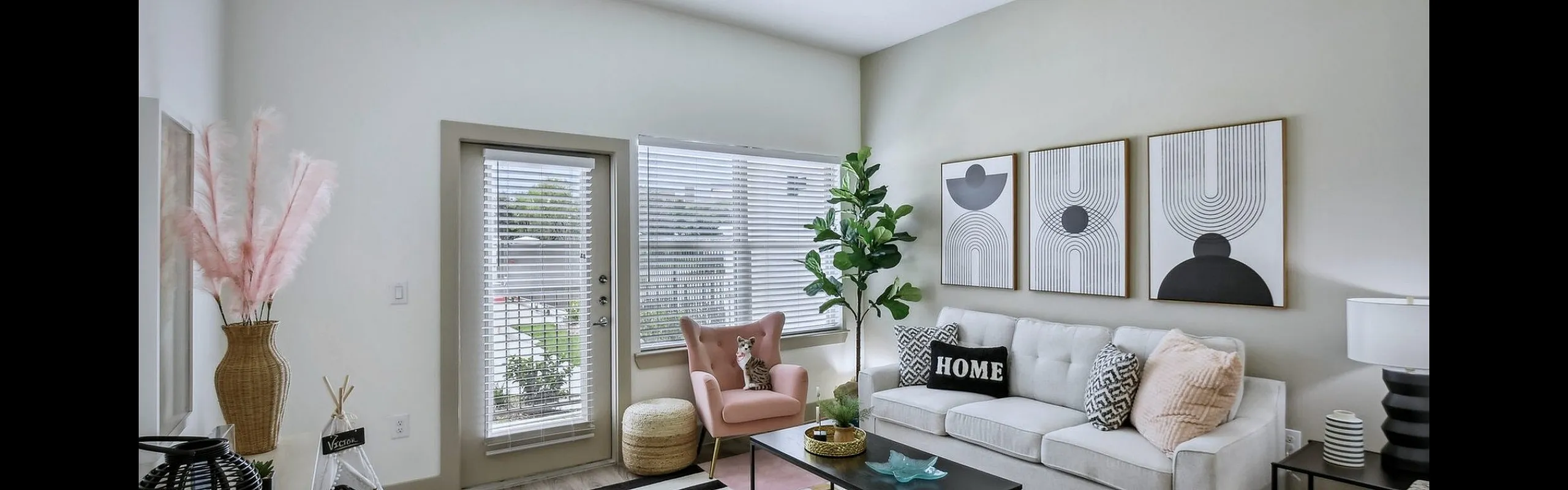 Modern living room with chic decor, featuring a plush white sofa, abstract wall art, and a vibrant area rug, inviting relaxation and style.