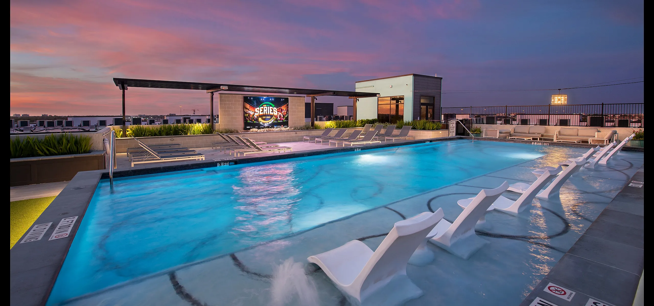 Luxurious rooftop pool with modern lounge chairs and stunning sunset views, perfect for relaxing in style.