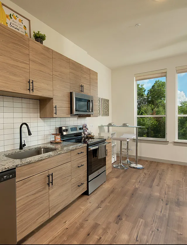 Modern kitchen with sleek wooden cabinetry, stainless steel appliances, and a cozy dining nook with bright natural light.