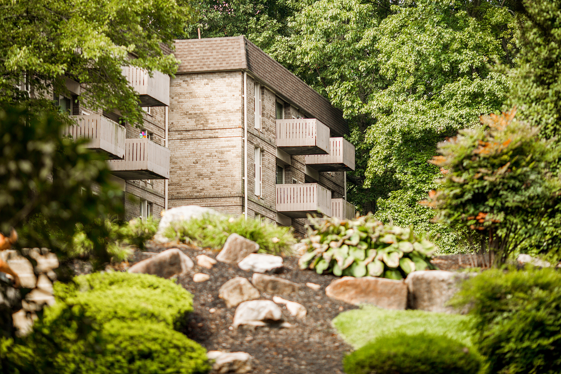 Exterior view of apartment with balconies and surrounding trees