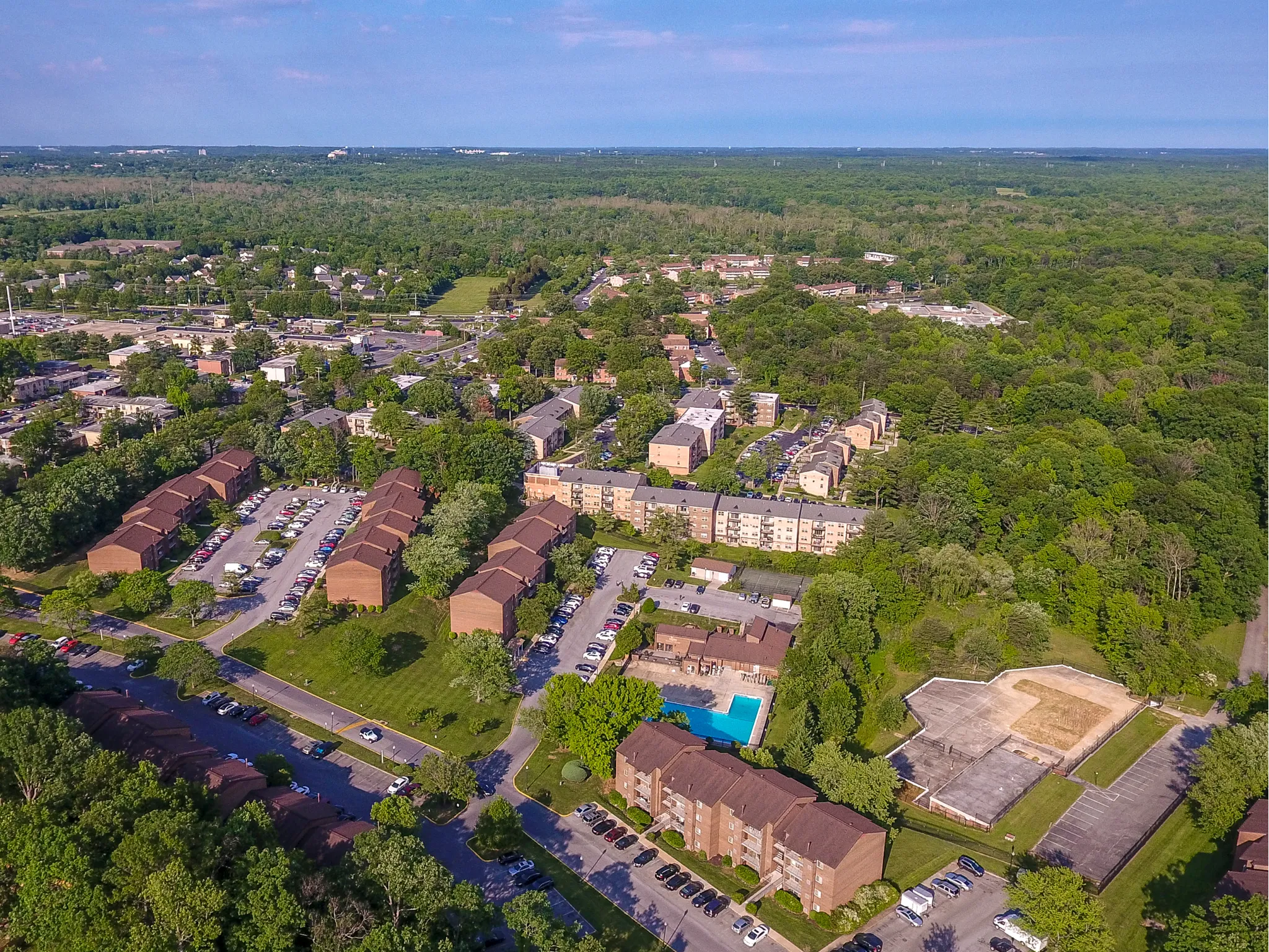 Aerial view of community with buildings surrounded by trees.