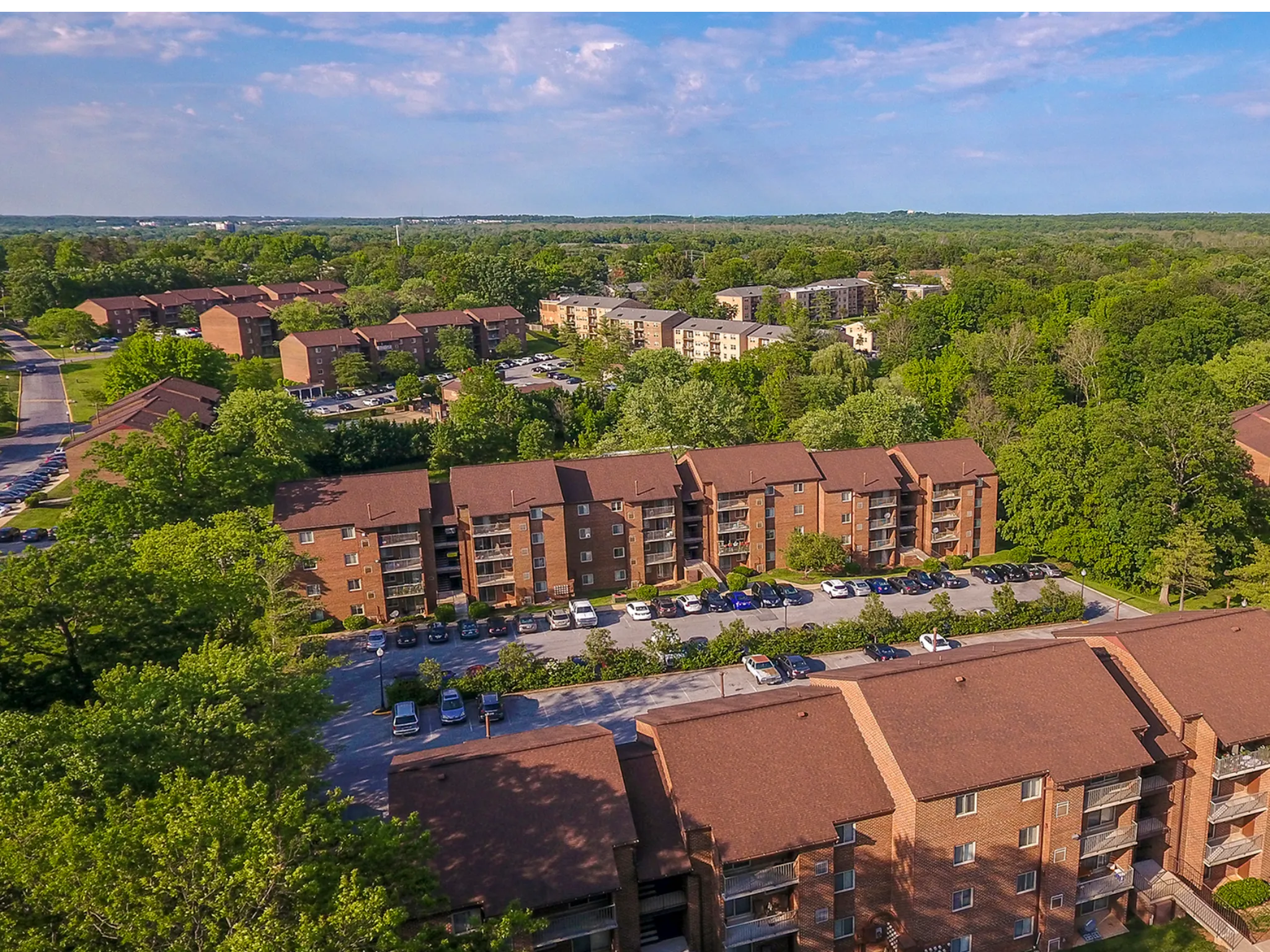 Aerial view of community with buildings surrounded by trees.