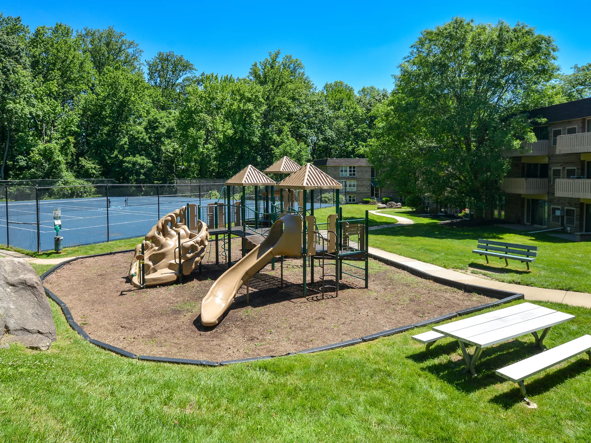 Playground with nearby tennis courts and picnic tables