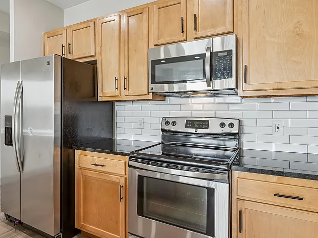 Modern kitchen with sleek stainless steel appliances and elegant wooden cabinetry.