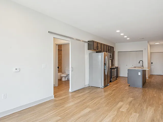 Bright and spacious open-concept kitchen with modern stainless steel appliances and elegant wood flooring.