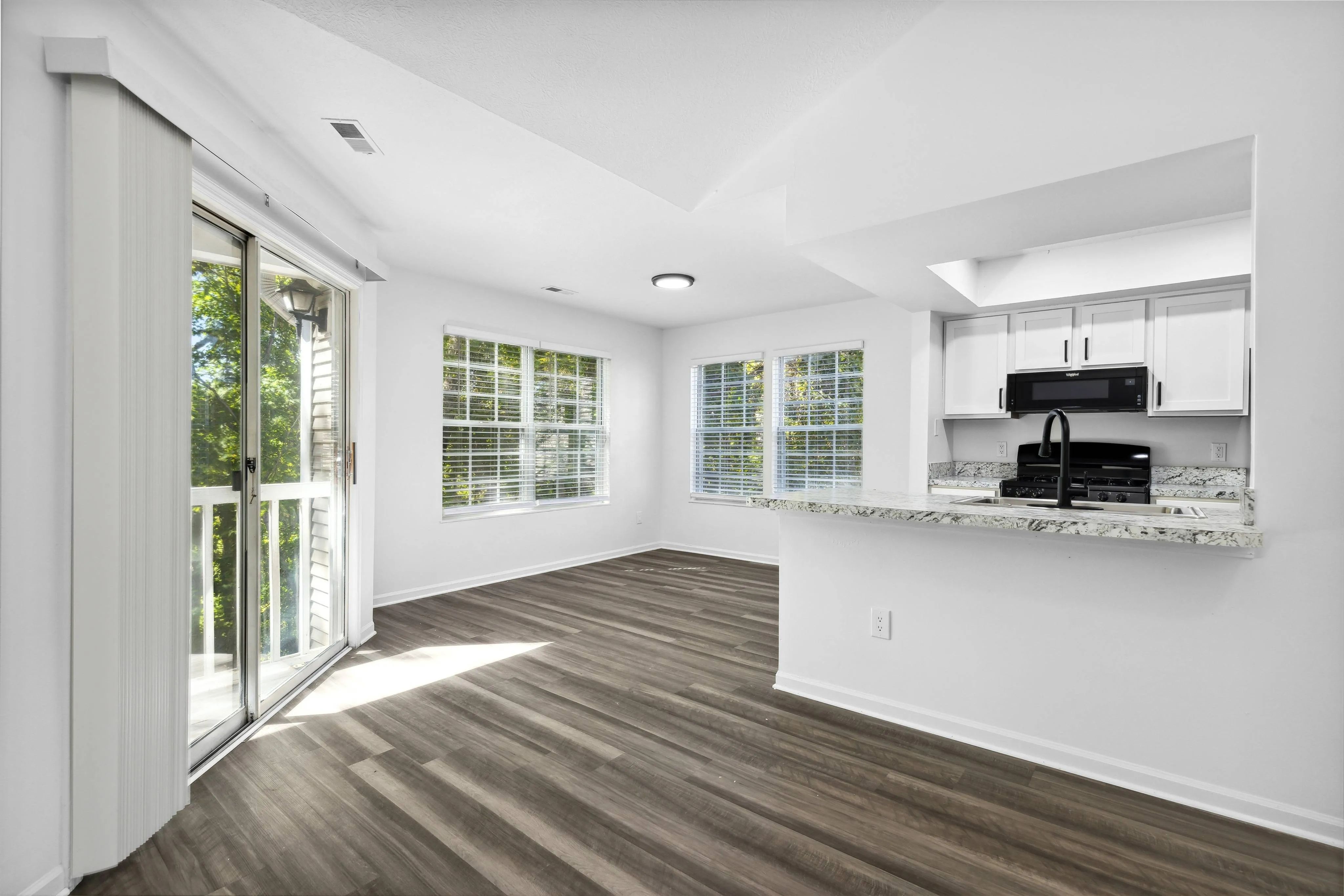 Renovated Apartment - Wood-plank flooring, sliding doors, ceiling fan in living area at  | The Residence at Turnberry | Columbus Apartments