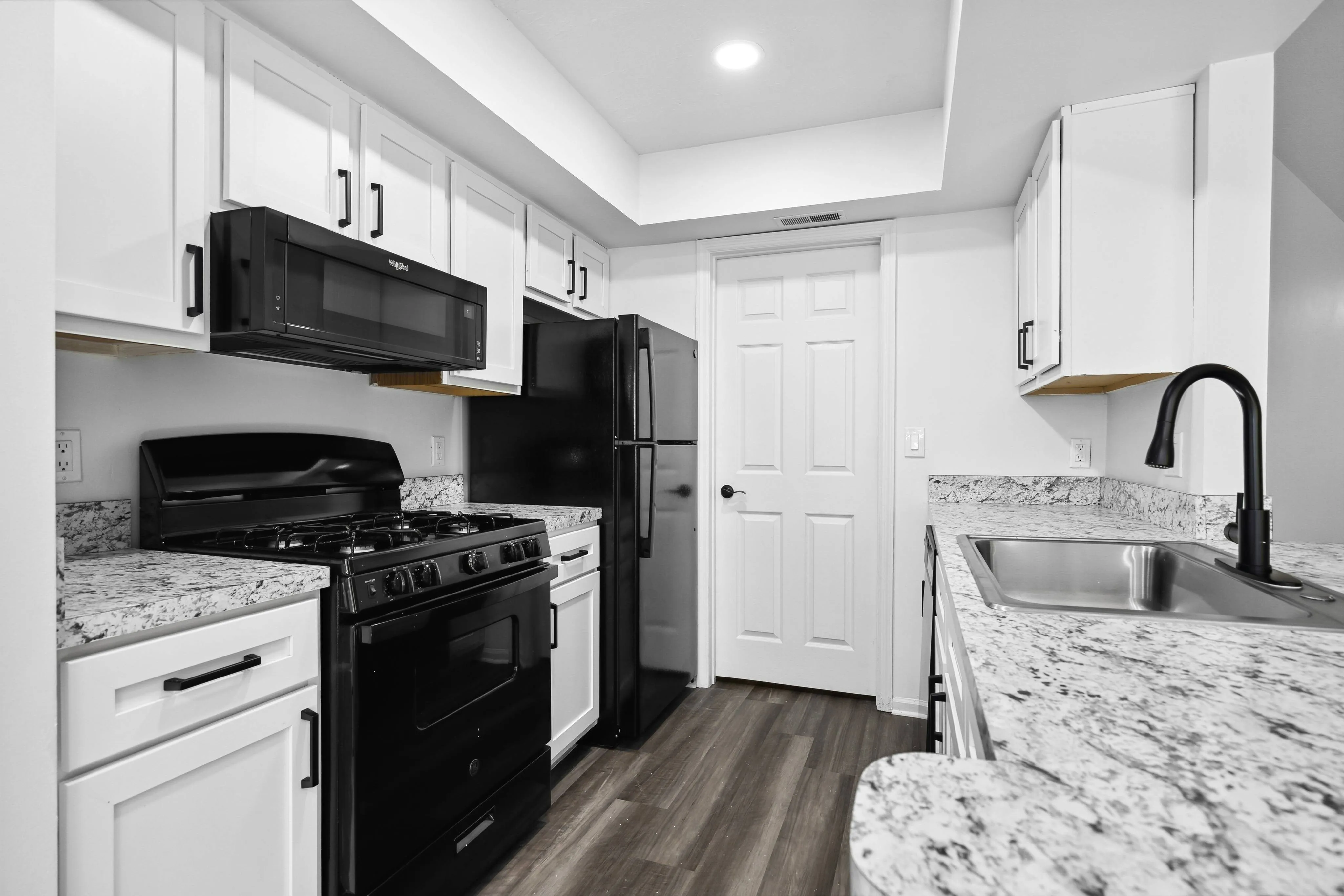 Renovated Apartment - Prep-friendly kitchen with black appliances white cabinetry at  | The Residence at Turnberry | Columbus Apartments