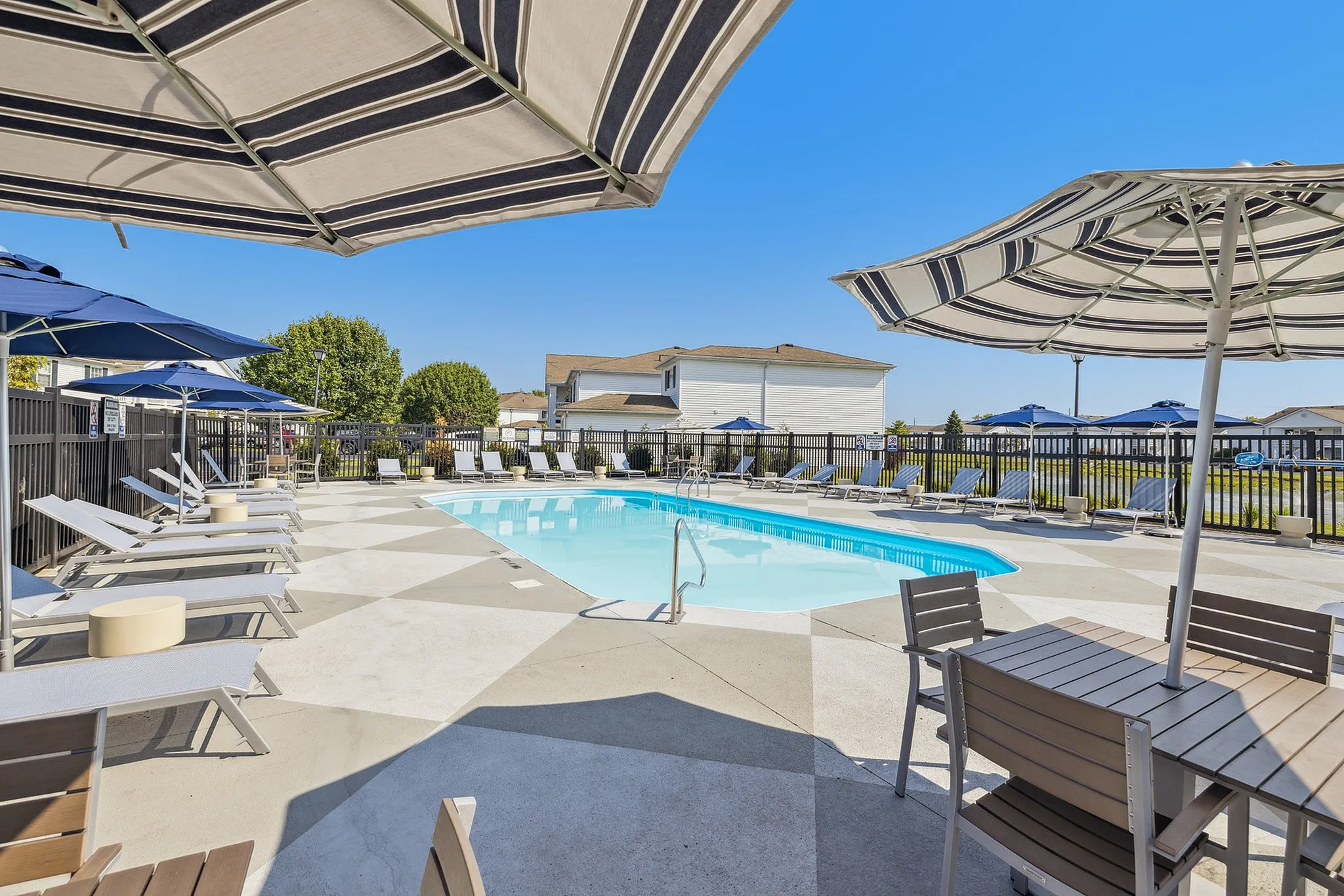 Inviting outdoor pool area with stylish lounge chairs and shaded seating, perfect for relaxation and social gatherings.