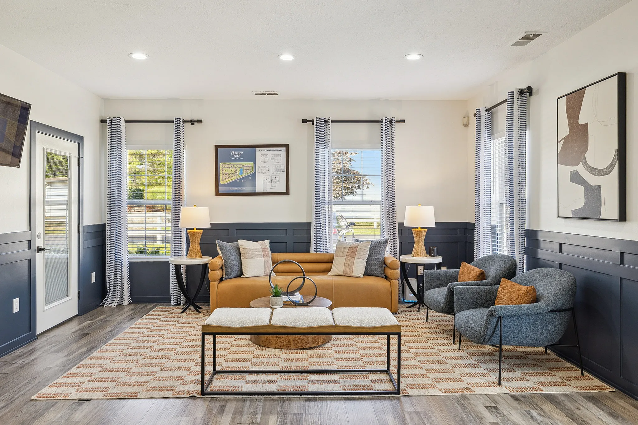 Chic living room with sleek modern decor, featuring a cozy sofa, stylish armchairs, and vibrant artwork, enhanced by abundant natural light.