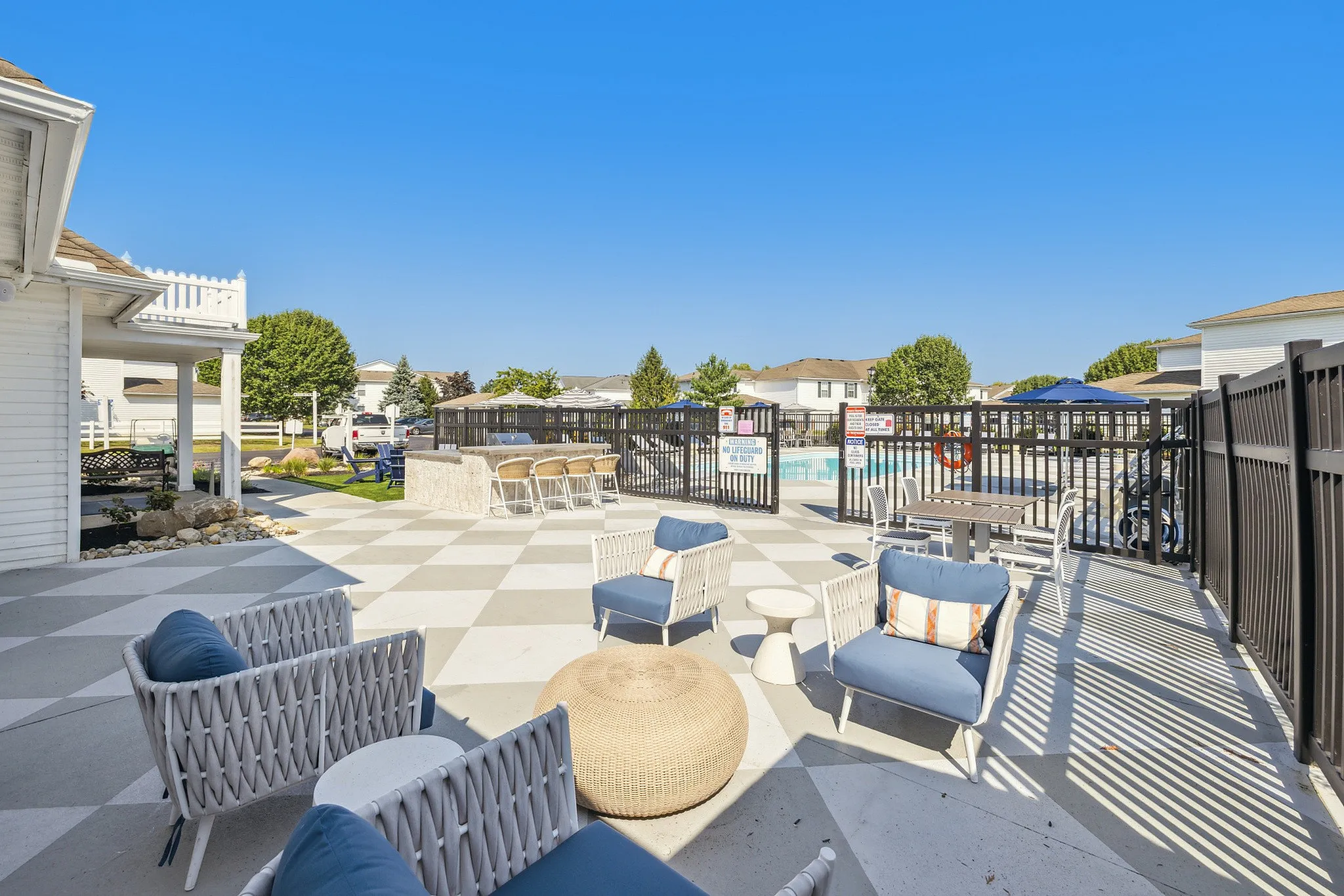 Chic outdoor lounge area with modern seating, overlooking a refreshing pool and stylish sunbathing spots, perfect for relaxation.