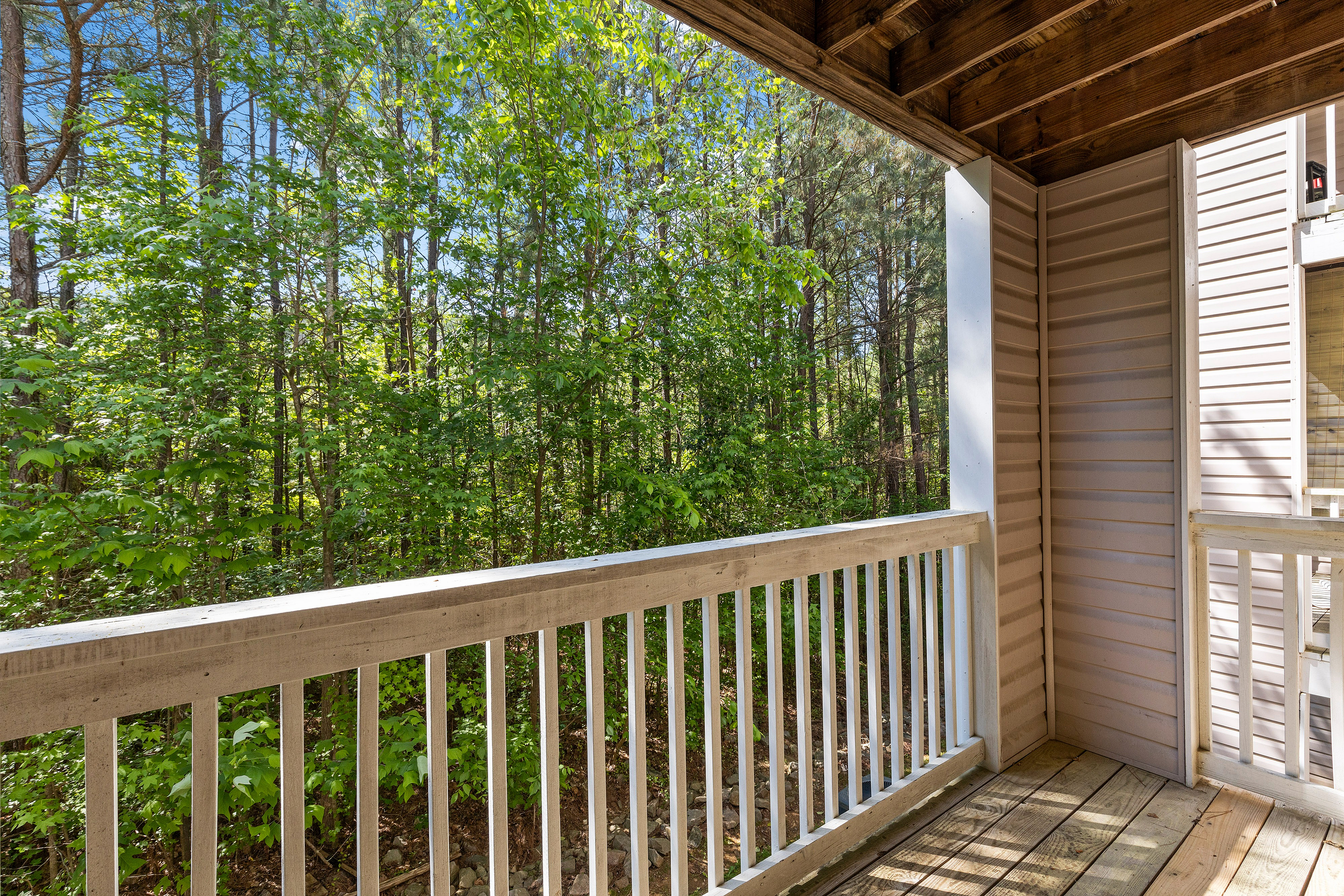 Charming apartment balcony with serene forest view, perfect for nature lovers seeking tranquility.