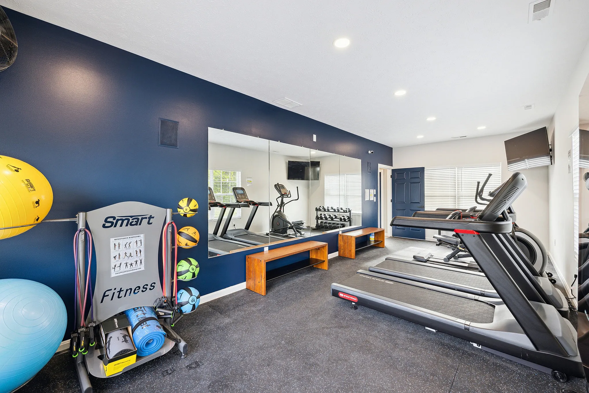 Modern fitness room featuring state-of-the-art treadmills, exercise equipment, and vibrant wall colors, perfect for an energizing workout.