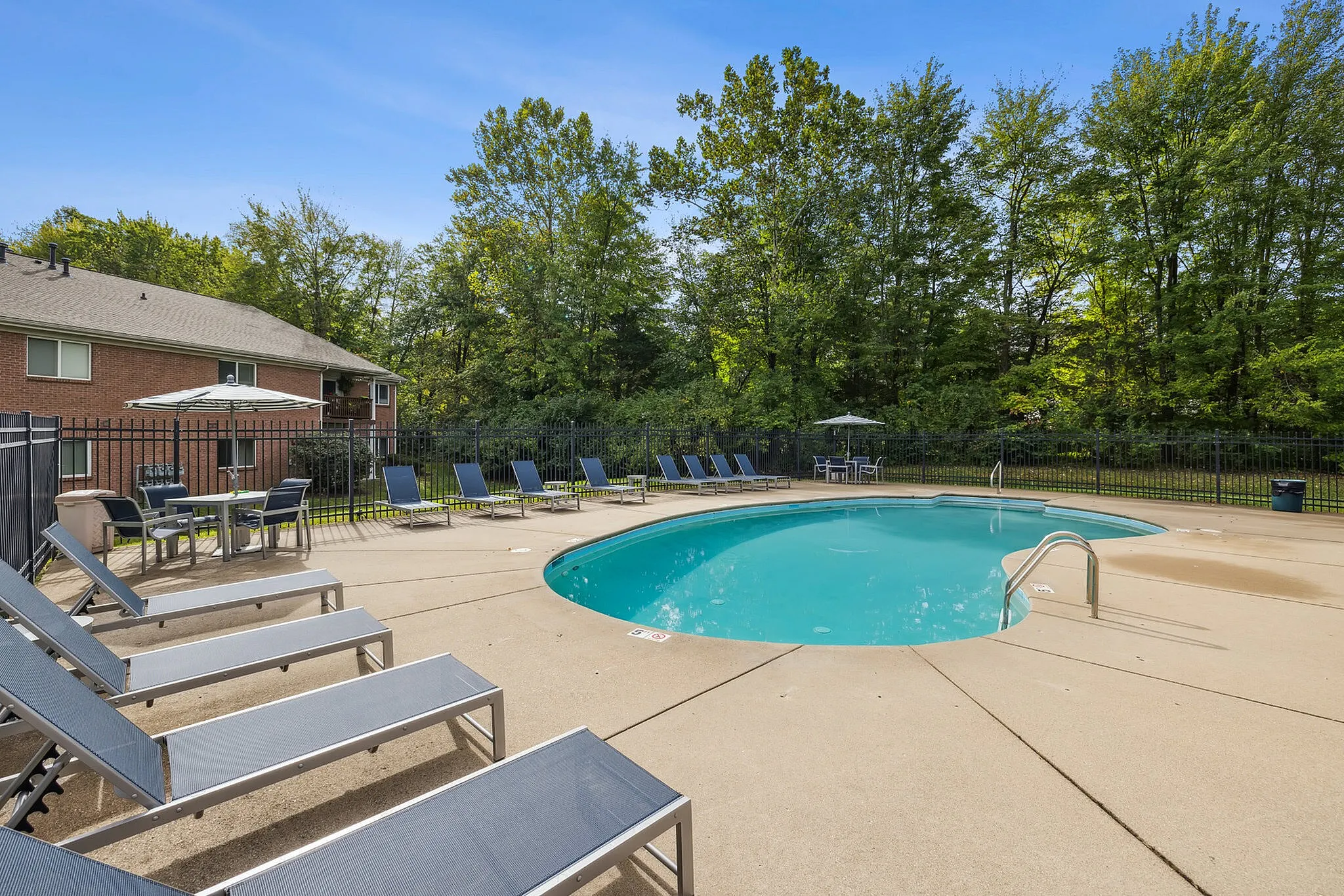 Inviting outdoor pool area with comfortable lounge chairs and a serene natural backdrop for ultimate relaxation.