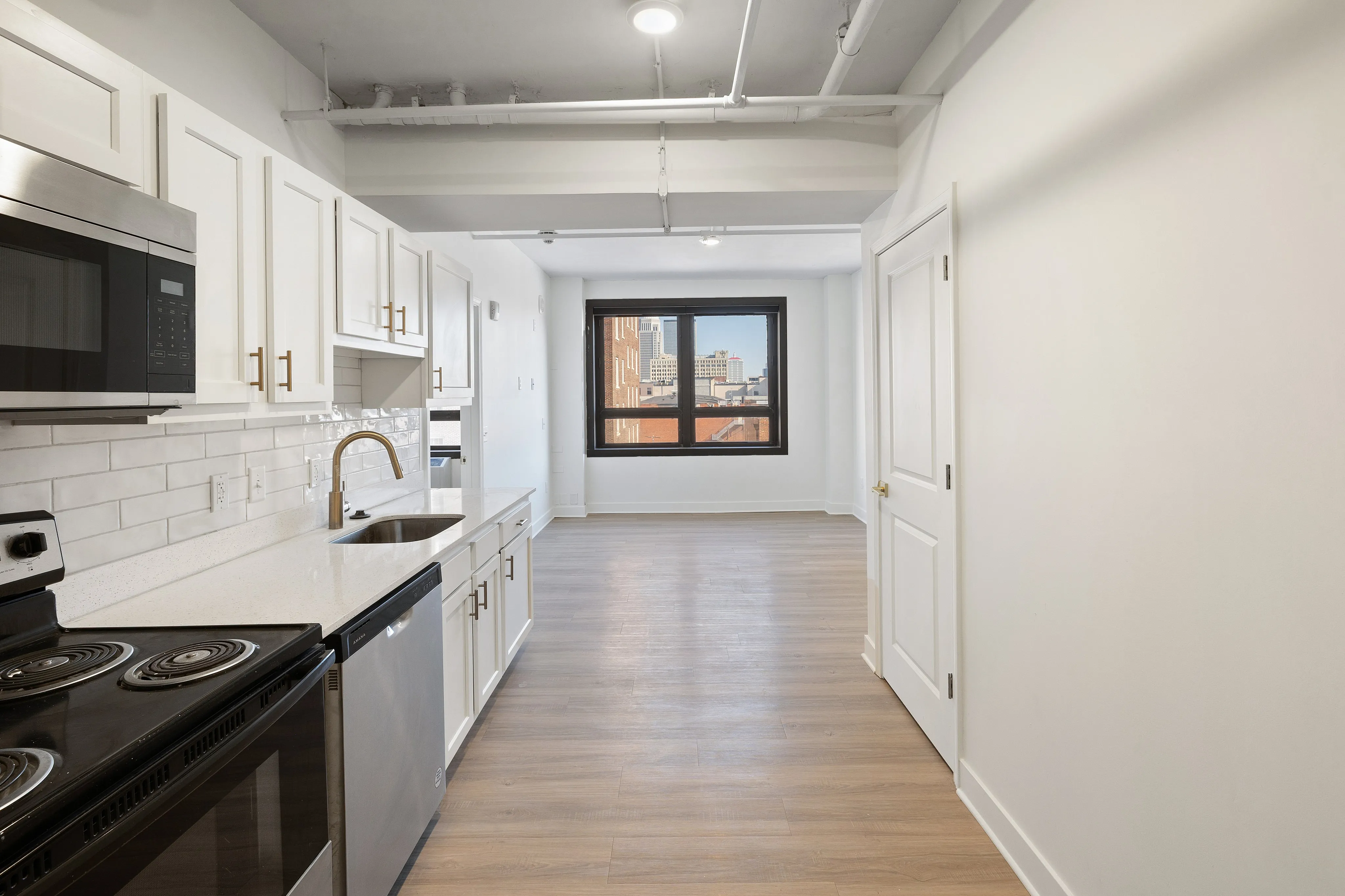 Modern kitchen with sleek appliances, stylish cabinetry, and an inviting dining area with natural light from a large window.