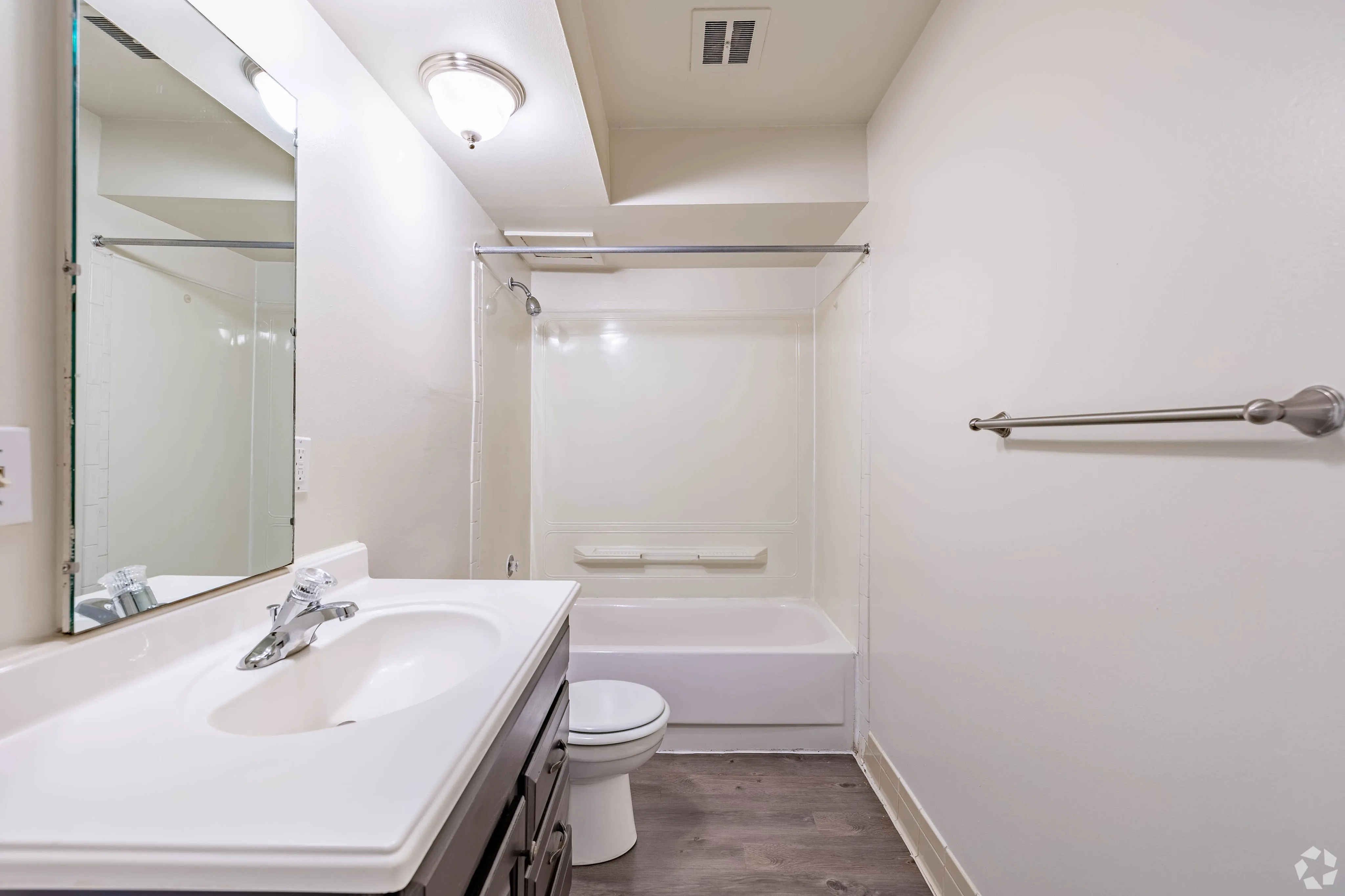 Modern bathroom featuring sleek fixtures, a spacious vanity, and a pristine bathtub with light, inviting decor.