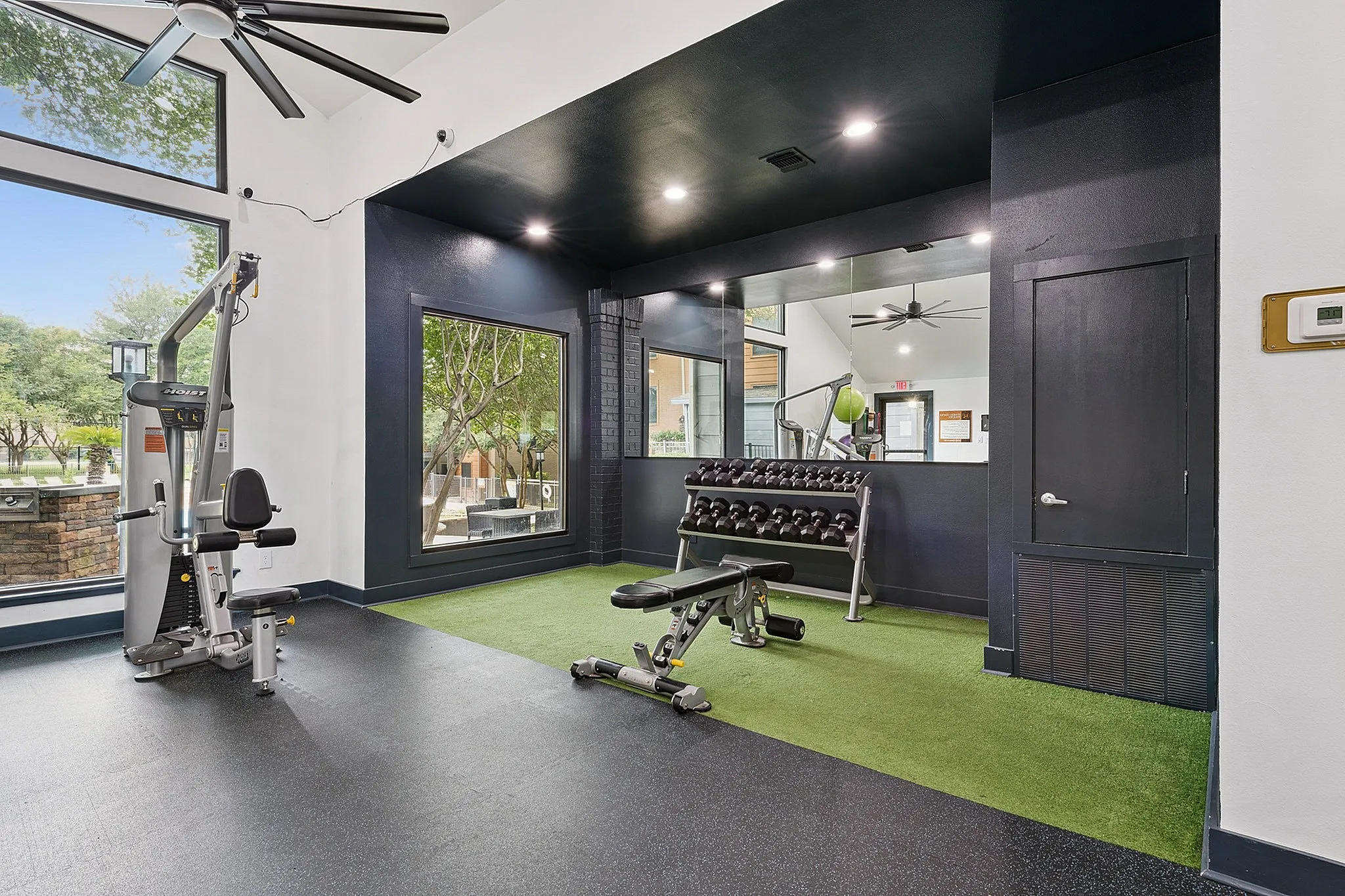 Modern fitness center with state-of-the-art equipment, large mirrors, and plenty of natural light.