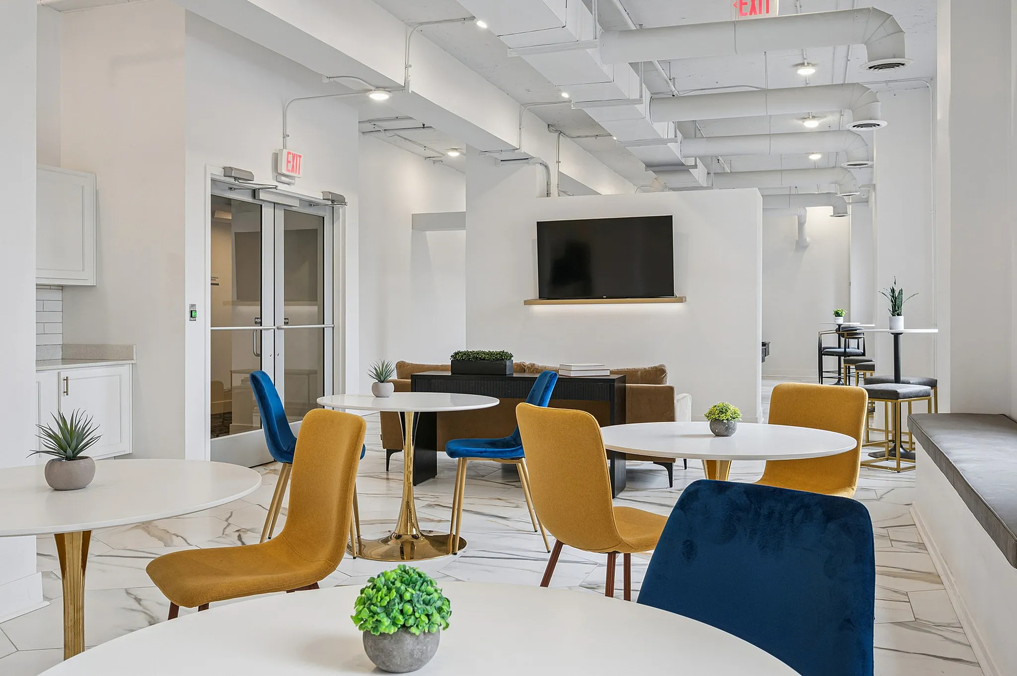 Chic and contemporary lounge area featuring stylish seating, elegant tables, and a modern wall-mounted TV, perfect for relaxation and social gatherings.