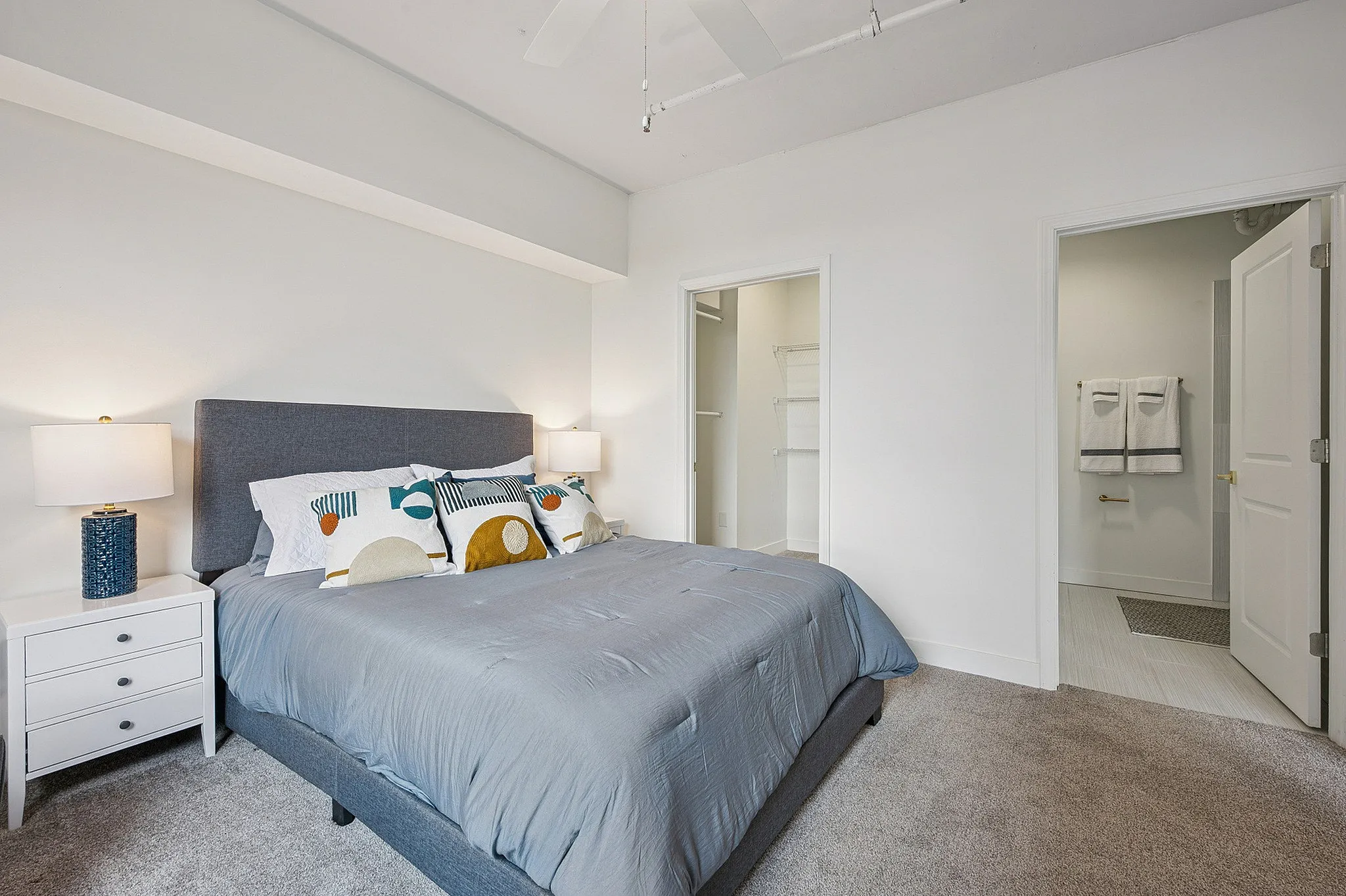 Elegant bedroom featuring a plush king-sized bed, stylish bedside tables with modern lamps, and a spacious walk-in closet connected to an en-suite bathroom.
