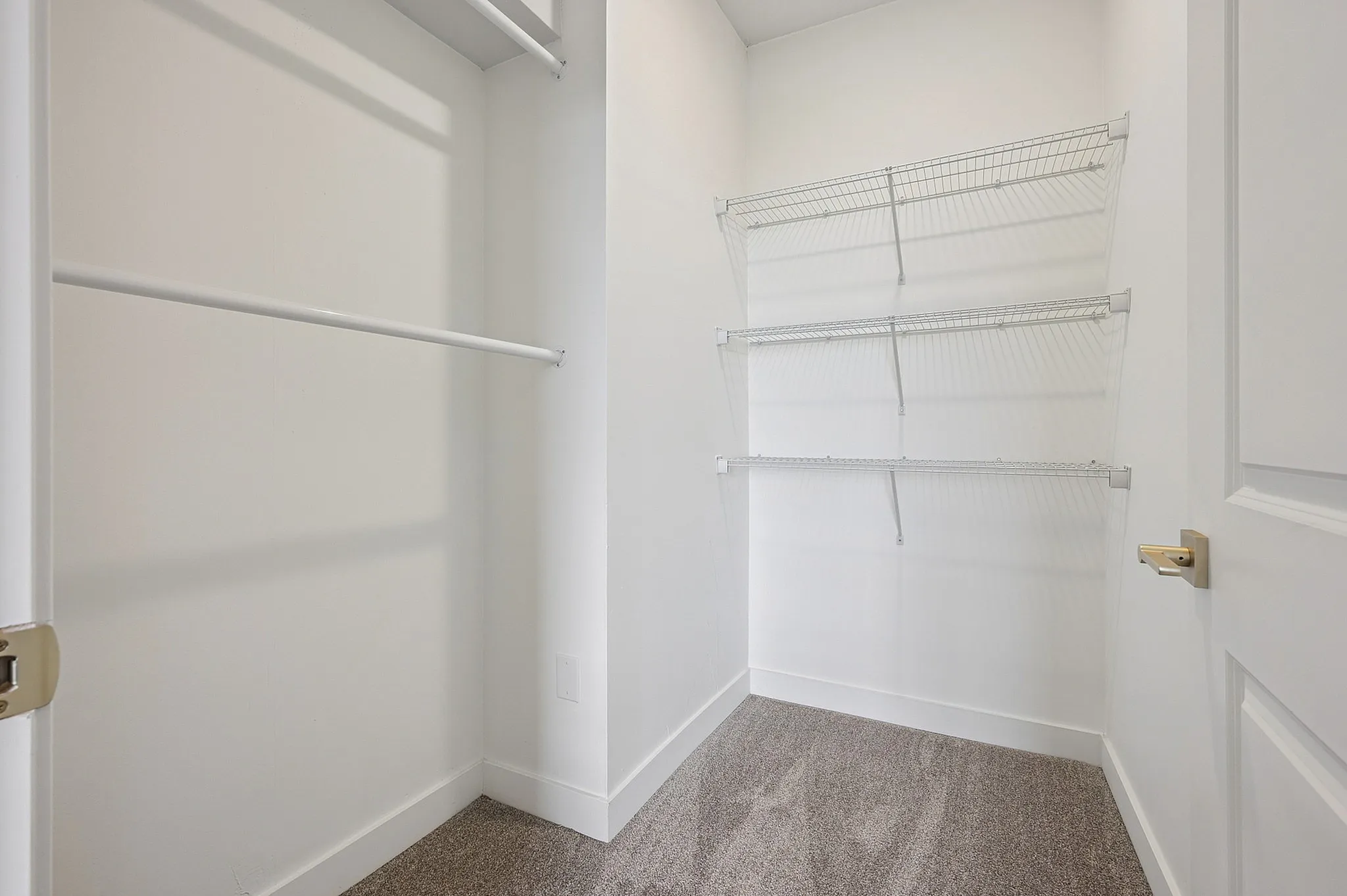 Spacious walk-in closet with modern shelving and ample hanging space, perfect for organized living.