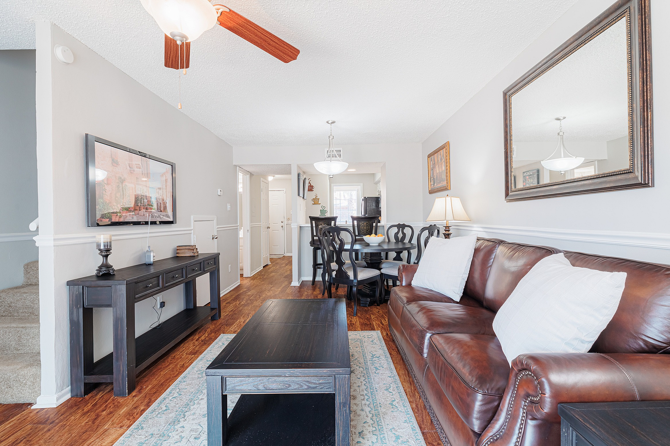 Bright living area with a luxurious leather sofa, elegant dining set, and stylish decor, perfect for entertaining.