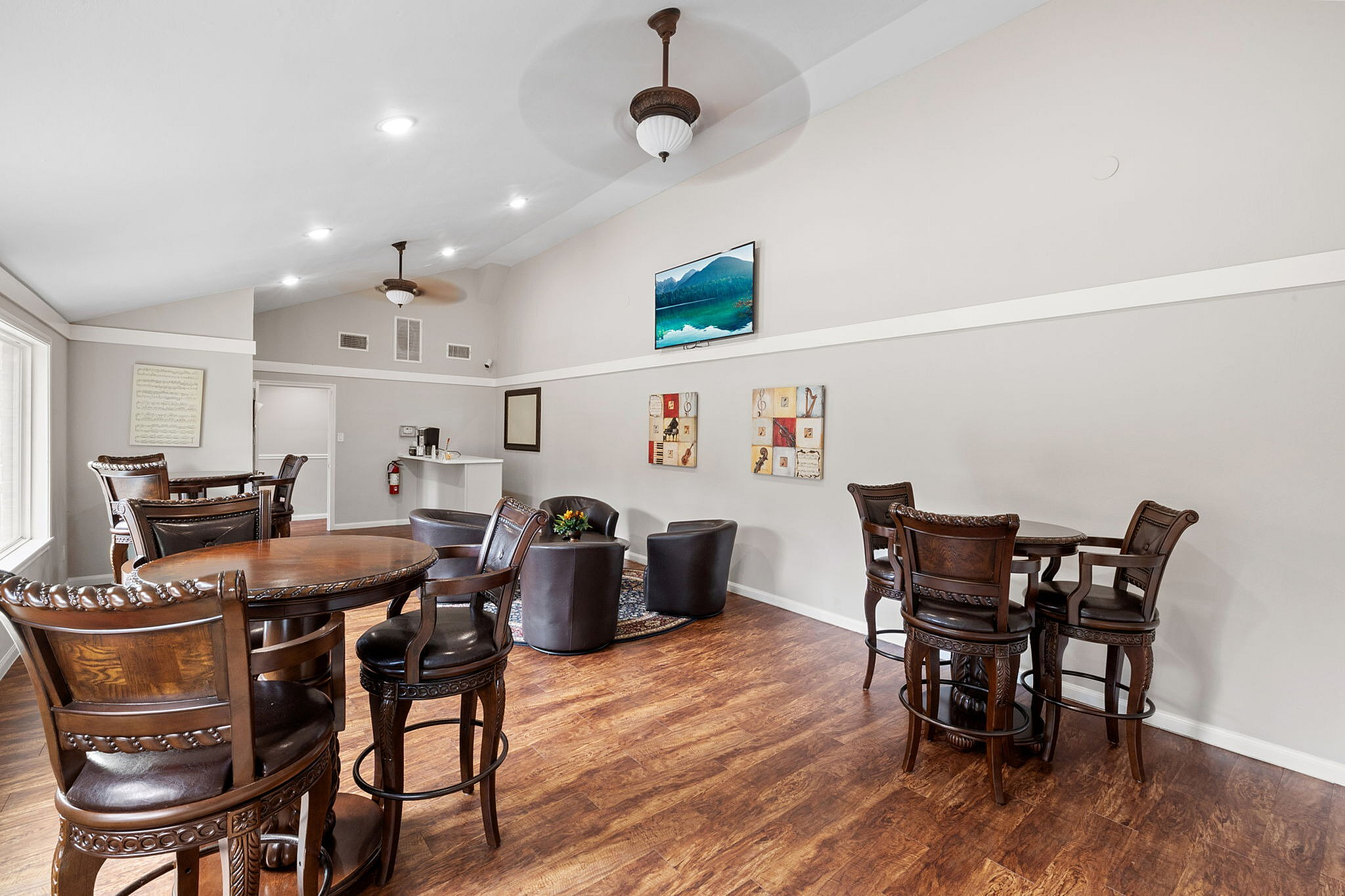 Elegant communal lounge with stylish wooden furniture, cozy seating area, and natural lighting, perfect for gatherings or relaxation.