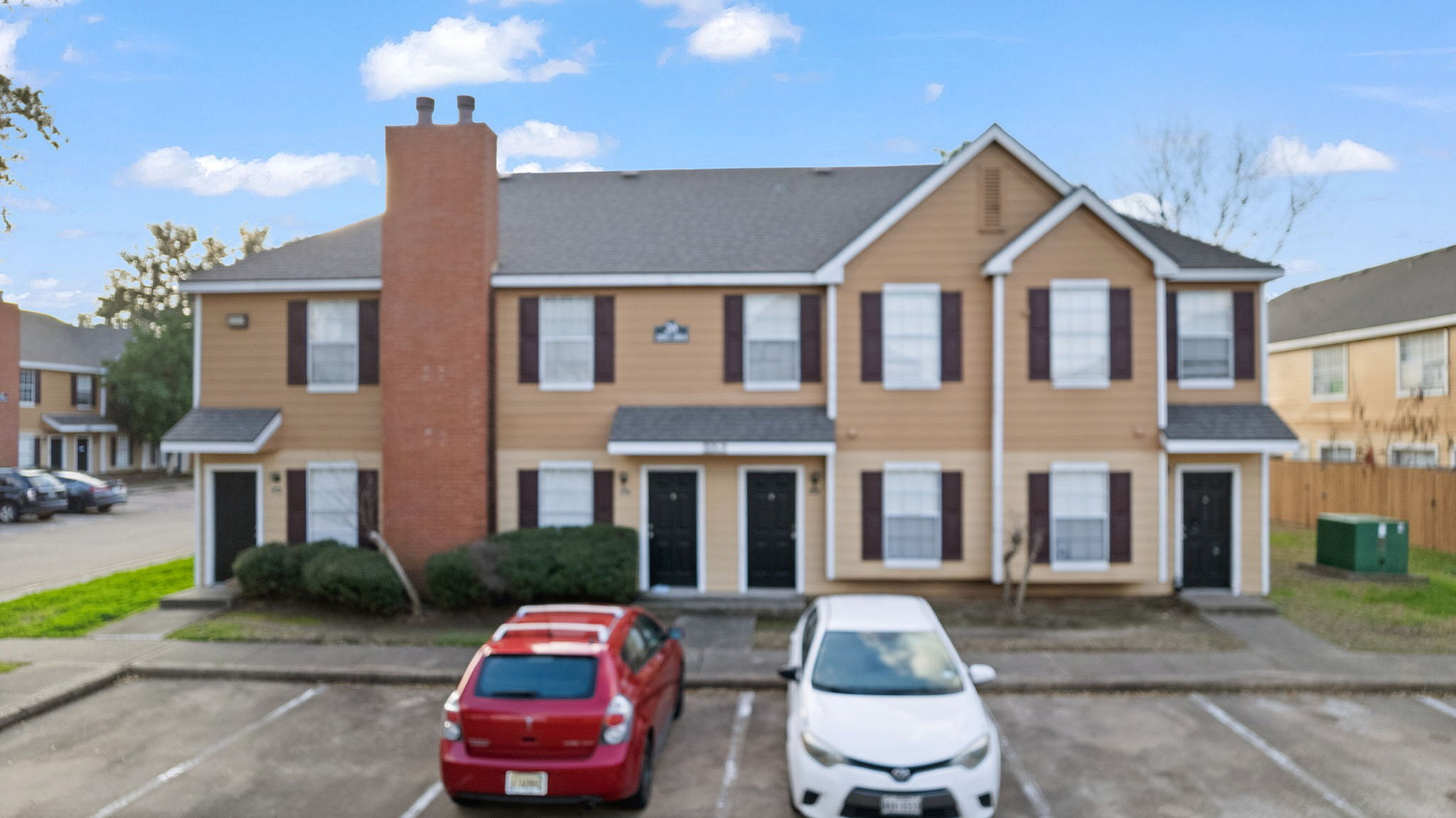 Charming duplex exterior with a modern design and ample parking in a peaceful neighborhood.