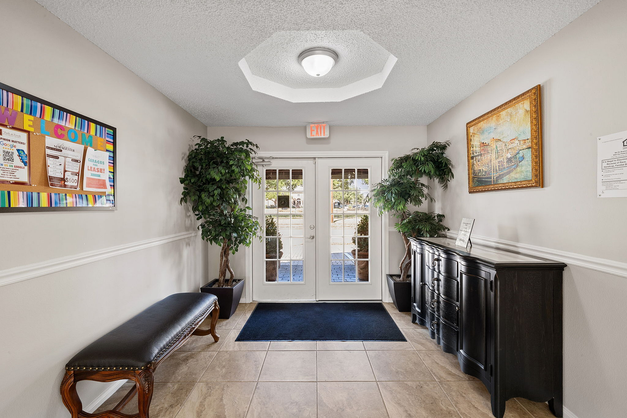 Inviting apartment entrance with elegant decor, featuring bright natural light, stylish furnishings, and vibrant welcome board.