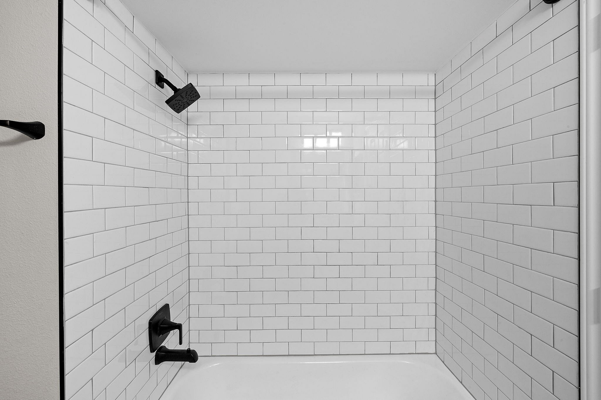 Modern bathroom showcasing sleek matte black fixtures and pristine white subway tiles for a stylish and contemporary look.