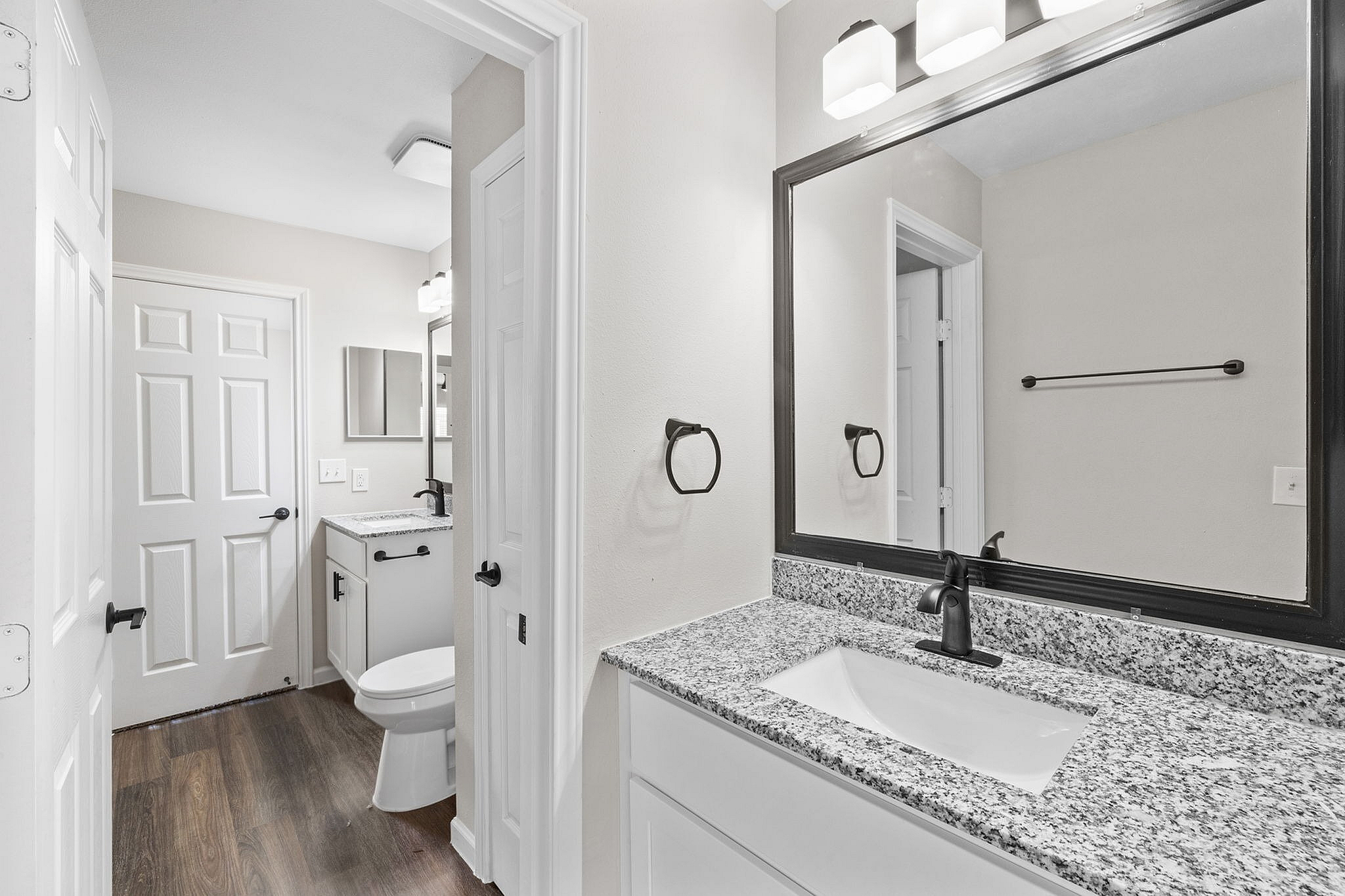 Chic bathroom showcasing a sleek granite countertop, modern fixtures, and elegant lighting, perfect for luxurious living.